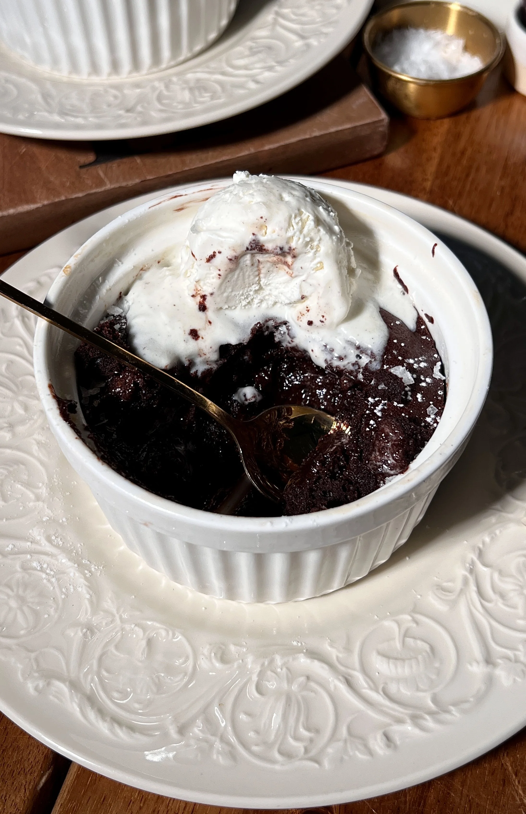 Warm flourless chocolate cakes for two served with vanilla ice cream and a sprinkle of flaky sea salt.
