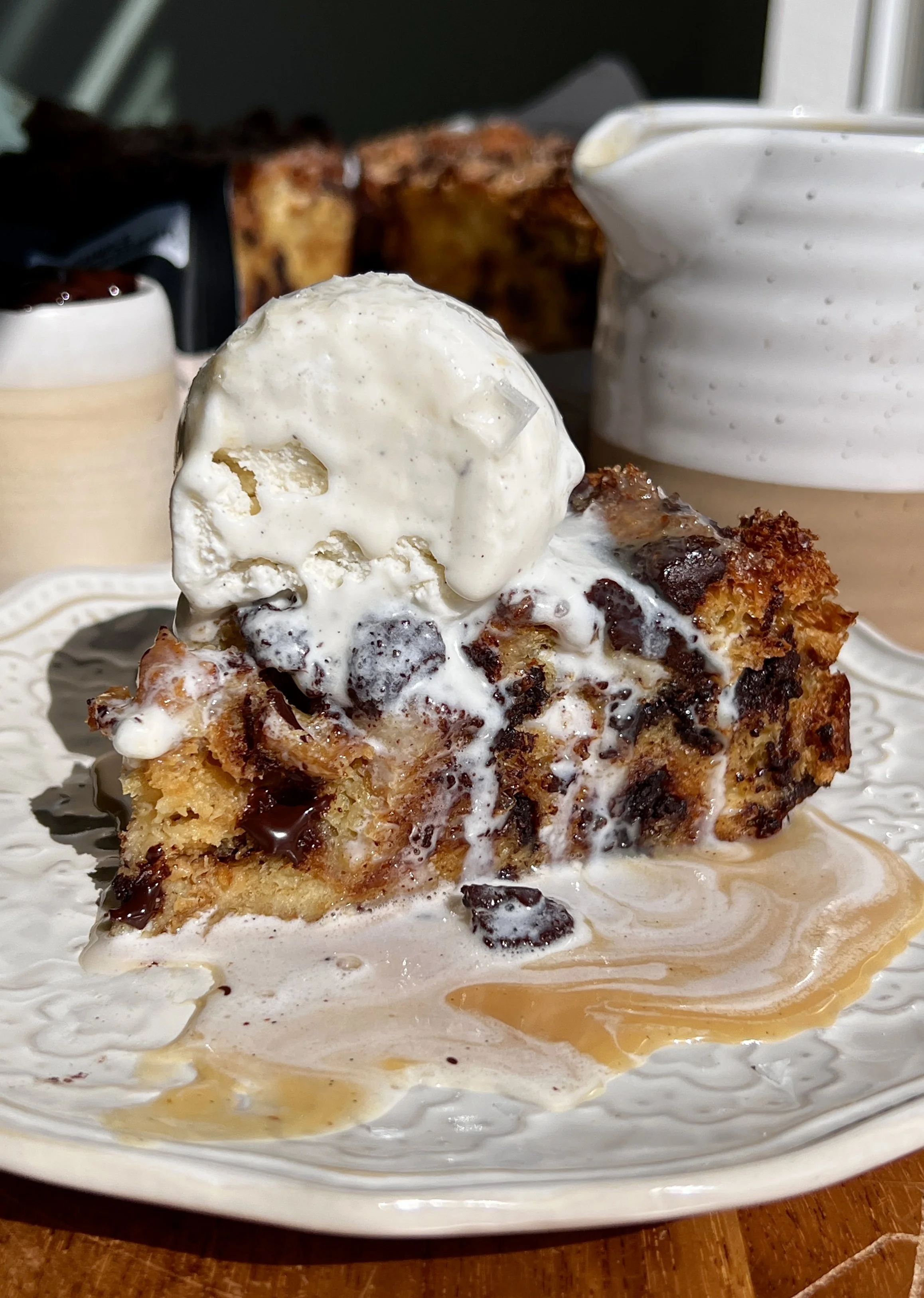 Warm chocolate chip bread pudding served with butter rum sauce, vanilla ice cream, and flaky sea salt.