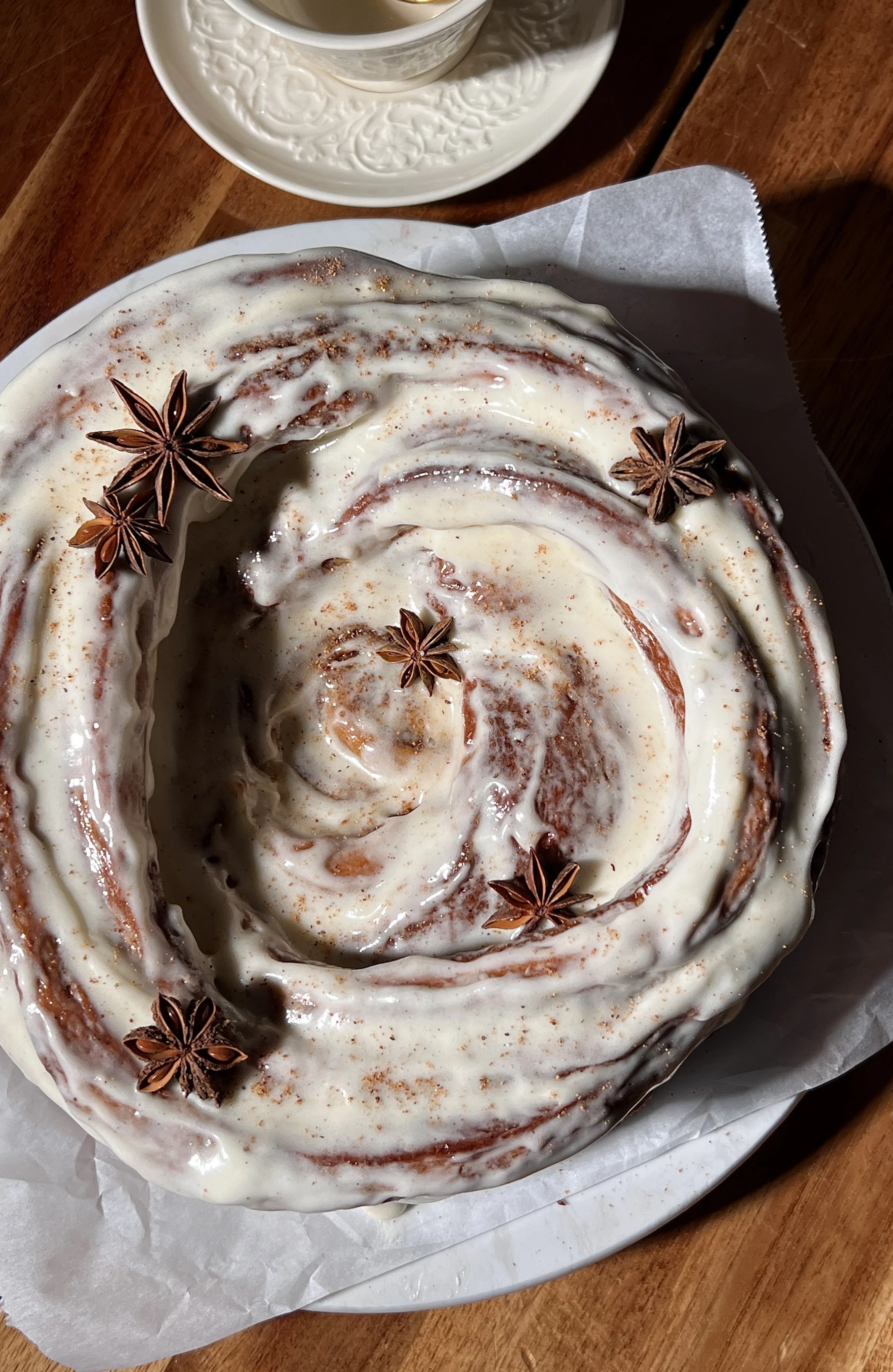 Close-up of a giant gingerbread cinnamon roll showing its soft, gooey center and cream cheese frosting.