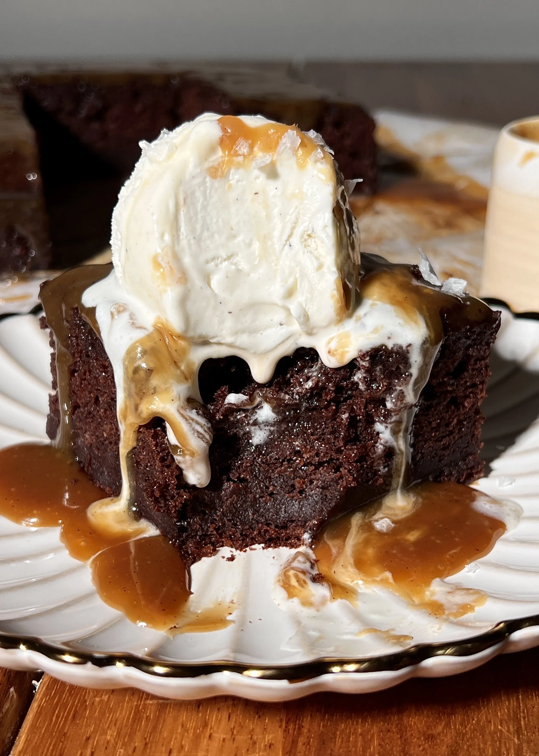 Warm chocolate espresso sticky toffee pudding topped with espresso toffee sauce and a scoop of vanilla ice cream.