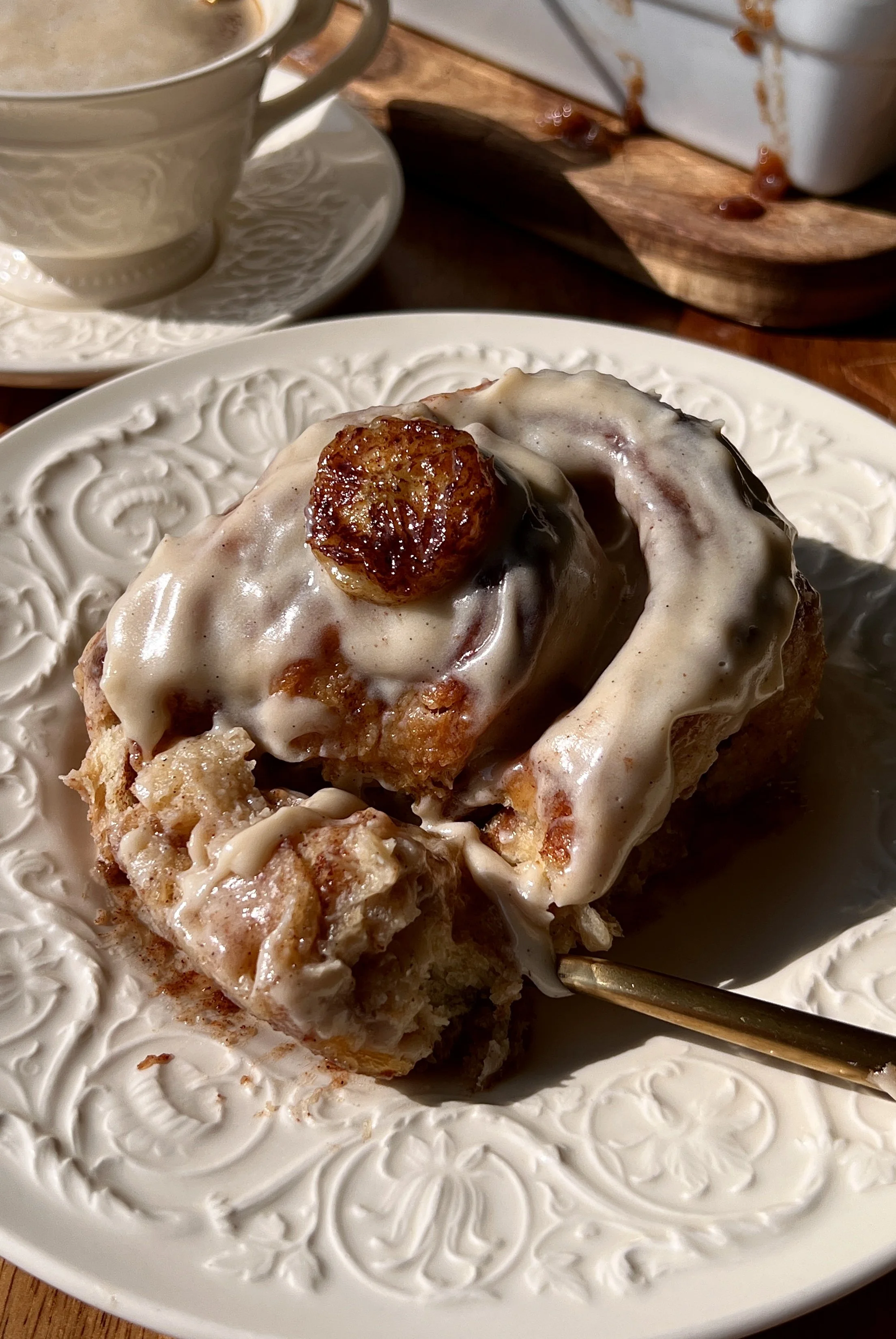 Incredibly soft and fluffy banana bread buttermilk cinnamon rolls with a warming banana bread cinnamon filling and beautifully golden caramelized edges finished with honey brown sugar cream cheese frosting served warm with a hot cup of coffee.