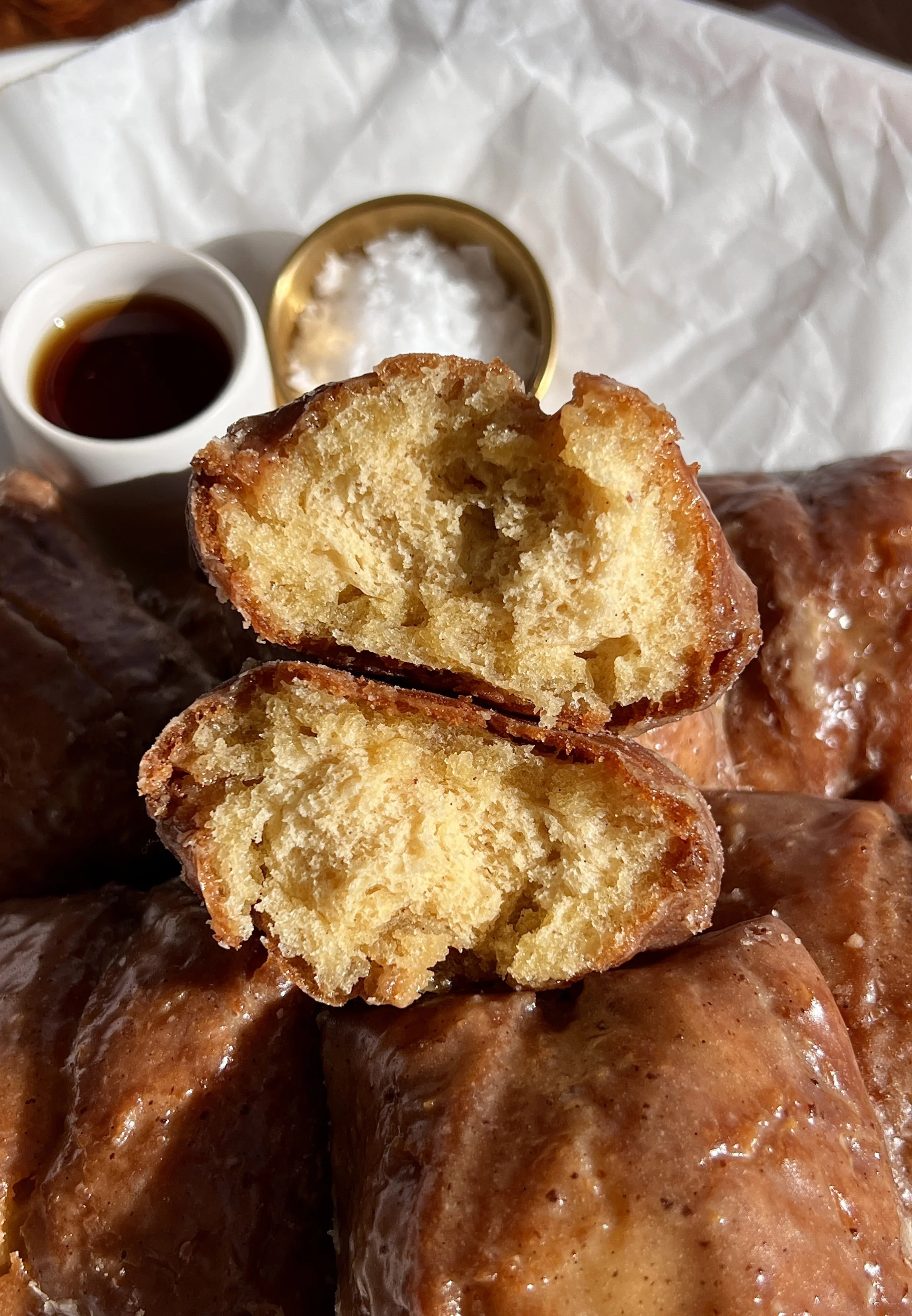 Close-up of a buttermilk donut bar showing tender crumb and brown butter maple vanilla bean glaze.