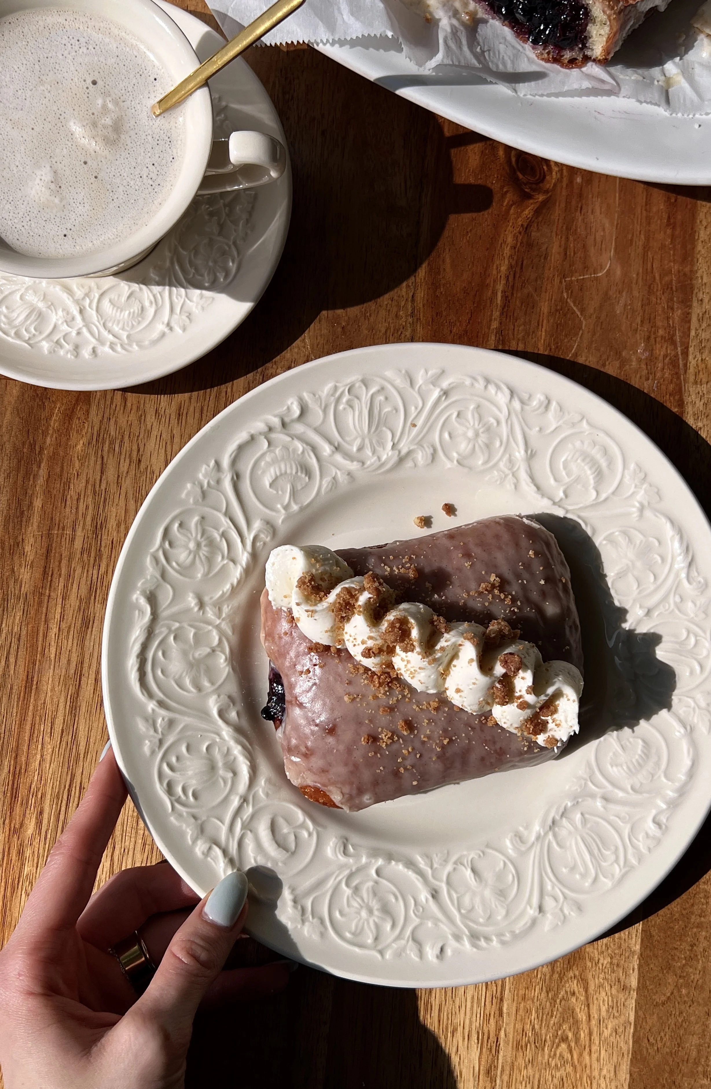 Pillowy soft and fluffy blueberry pie donut bars fried until golden, coated in a silky vanilla bean glaze, and finished with whipped buttercream and buttery shortbread crumbles served warm with a hot cup of coffee.