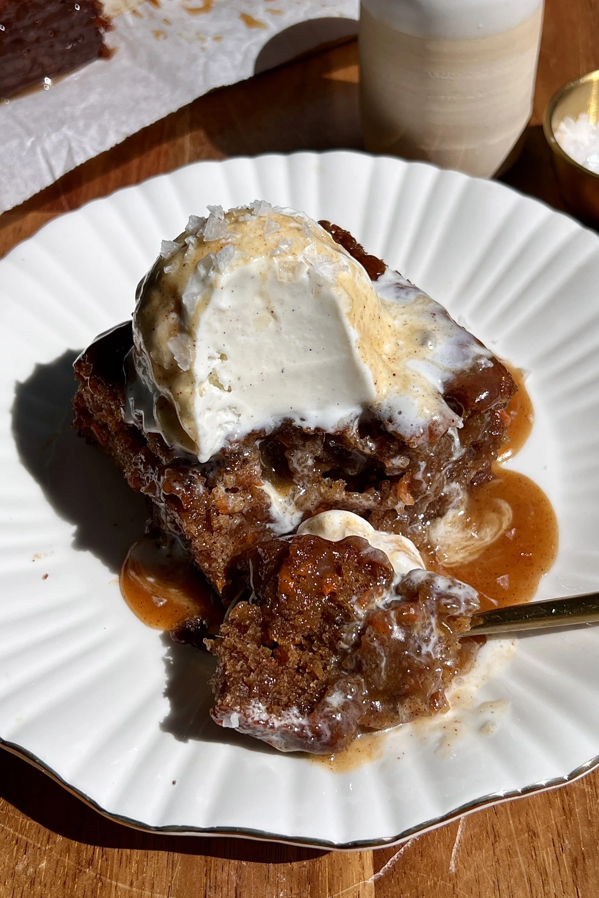 Warm carrot cake sticky toffee pudding served with spiced toffee sauce, vanilla ice cream, and flaky sea salt.