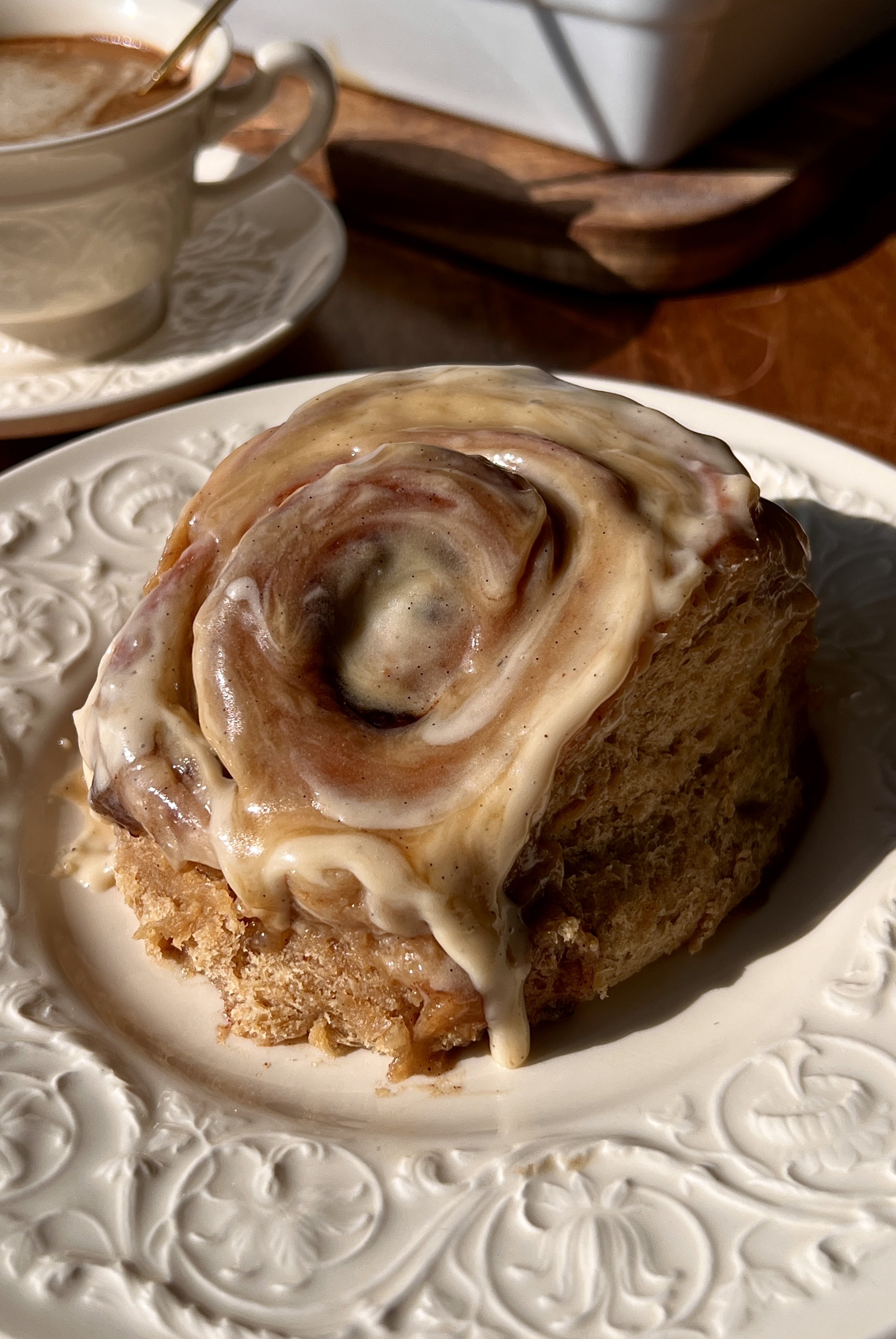Soft and fluffy sticky toffee pudding cinnamon rolls with a pull-apart date dough and warm gooey cinnamon date filling finished with a rich maple toffee sauce and brown sugar cream cheese frosting served warm with a hot cup of coffee.