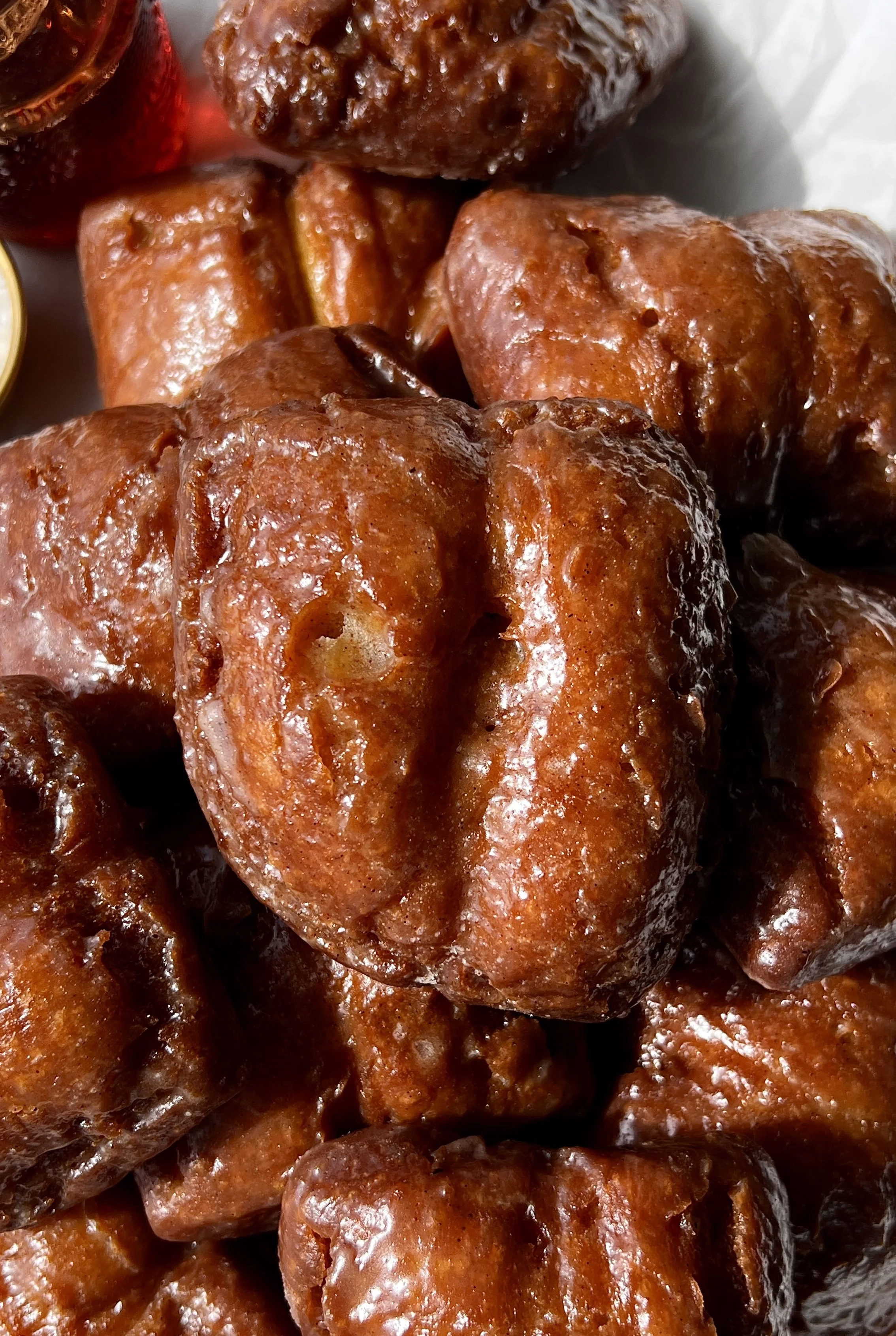 Close-up of an old-fashioned pumpkin donut bar showing the soft and fluffy delicate crumb with a beautifully golden and crisp exterior coated in a salted maple cinnamon glaze throughout.