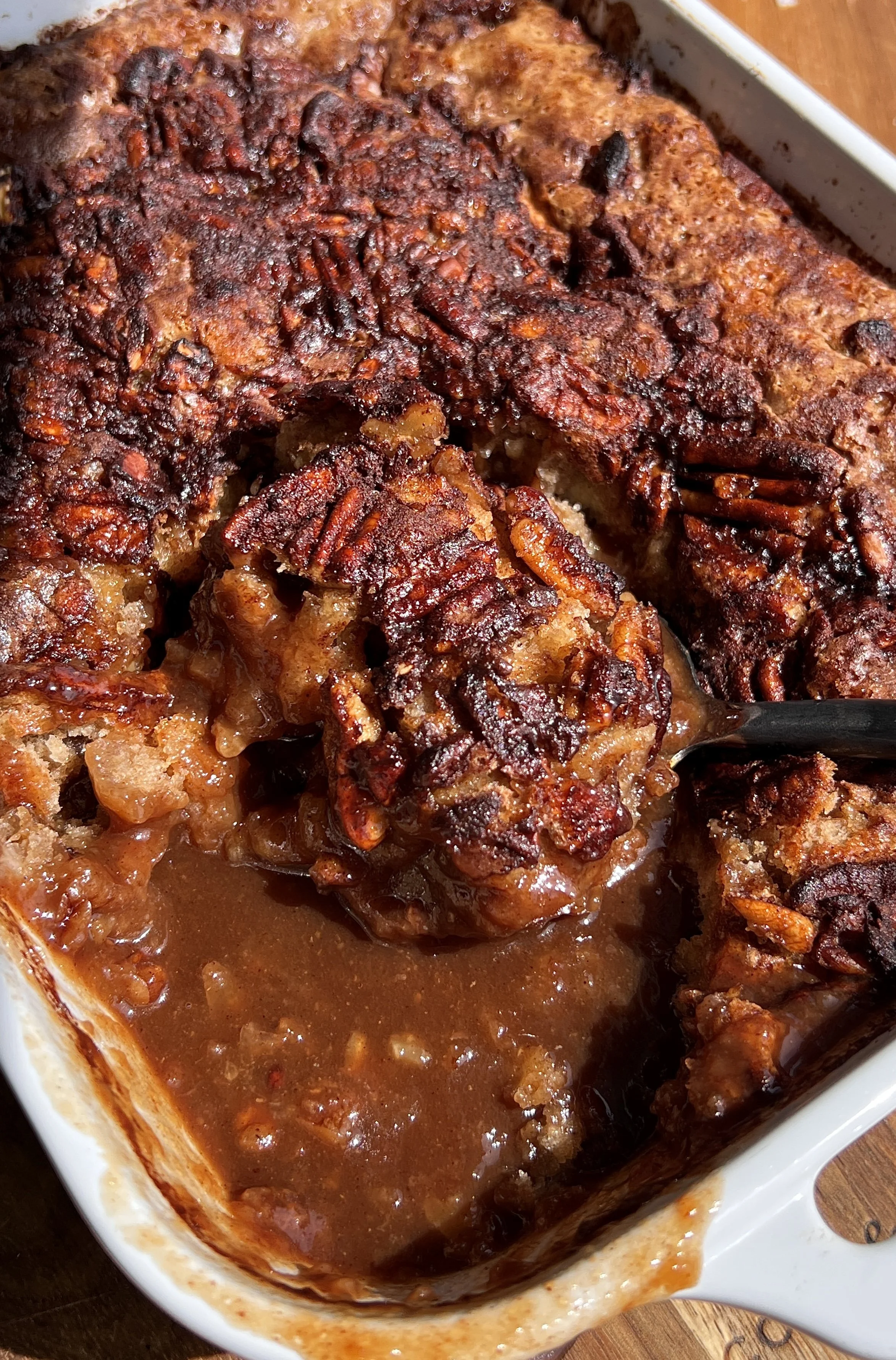 Close-up of self-saucing banana pudding cake with gooey syrupy bottom and soft golden cake top.