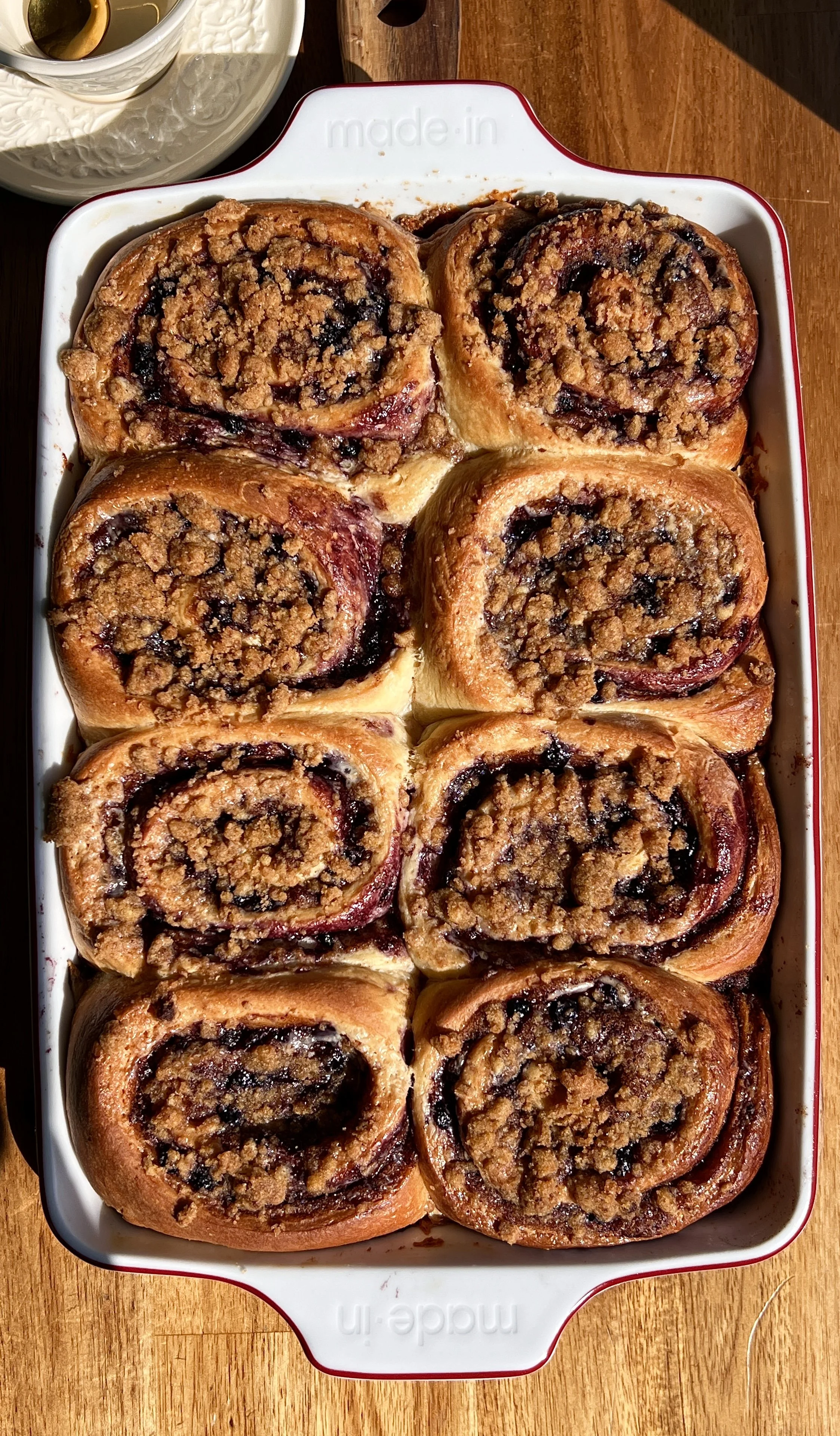 Close-up of blueberry cinnamon rolls with gooey brown sugar swirls, blueberry compote, and creamy glaze.