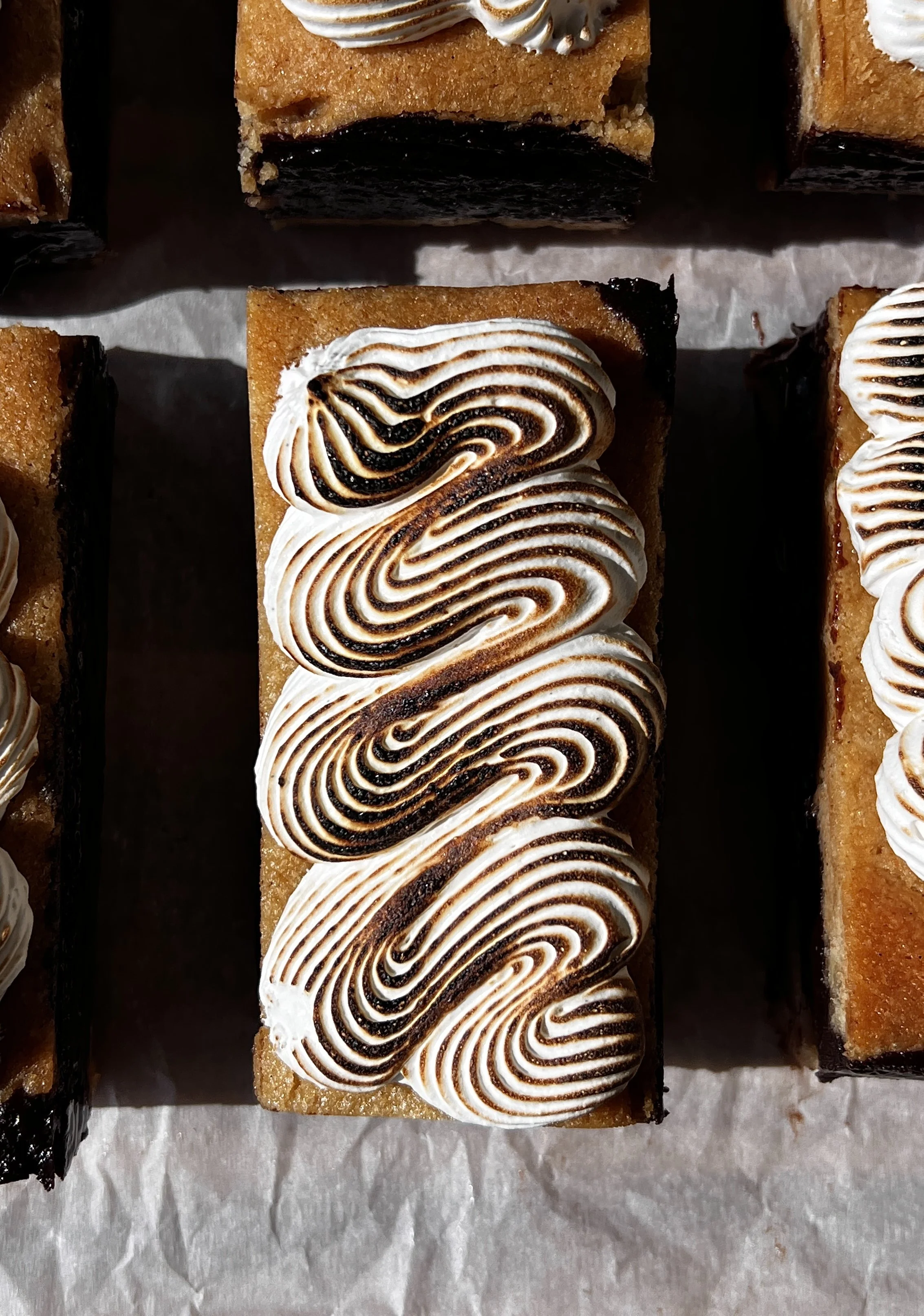 Close-up of a s'mores fudge shortbread bar showing the soft buttery graham cracker shortbread base, rich decadent fudge layer, and perfectly toasted marshmallow creme on top.