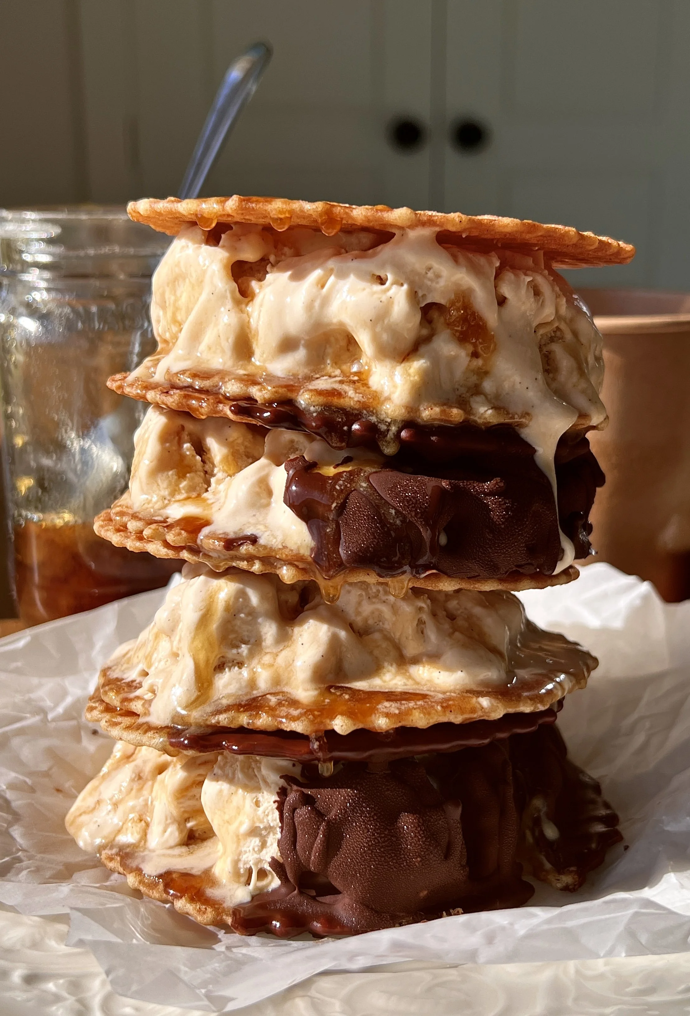 Close-up of a salted maple swirl ice cream sandwich showing the rich and creamy maple custard ice cream with a thick salted maple syrup swirl between two buttery waffle cookies.