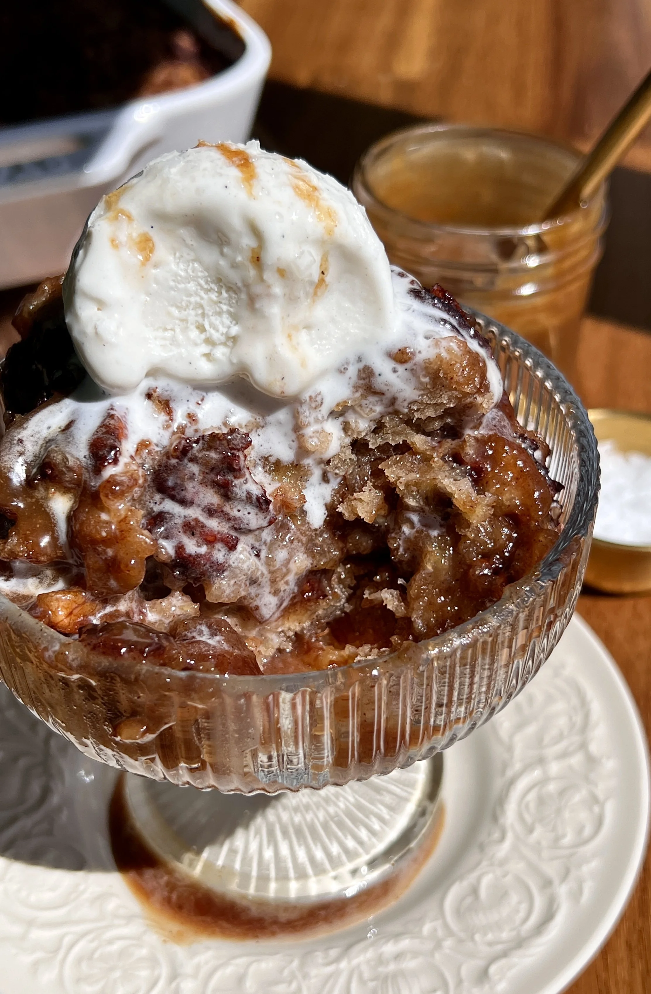 Warm self-saucing banana pudding cake served with vanilla ice cream, toasted pecans, and flaky sea salt.