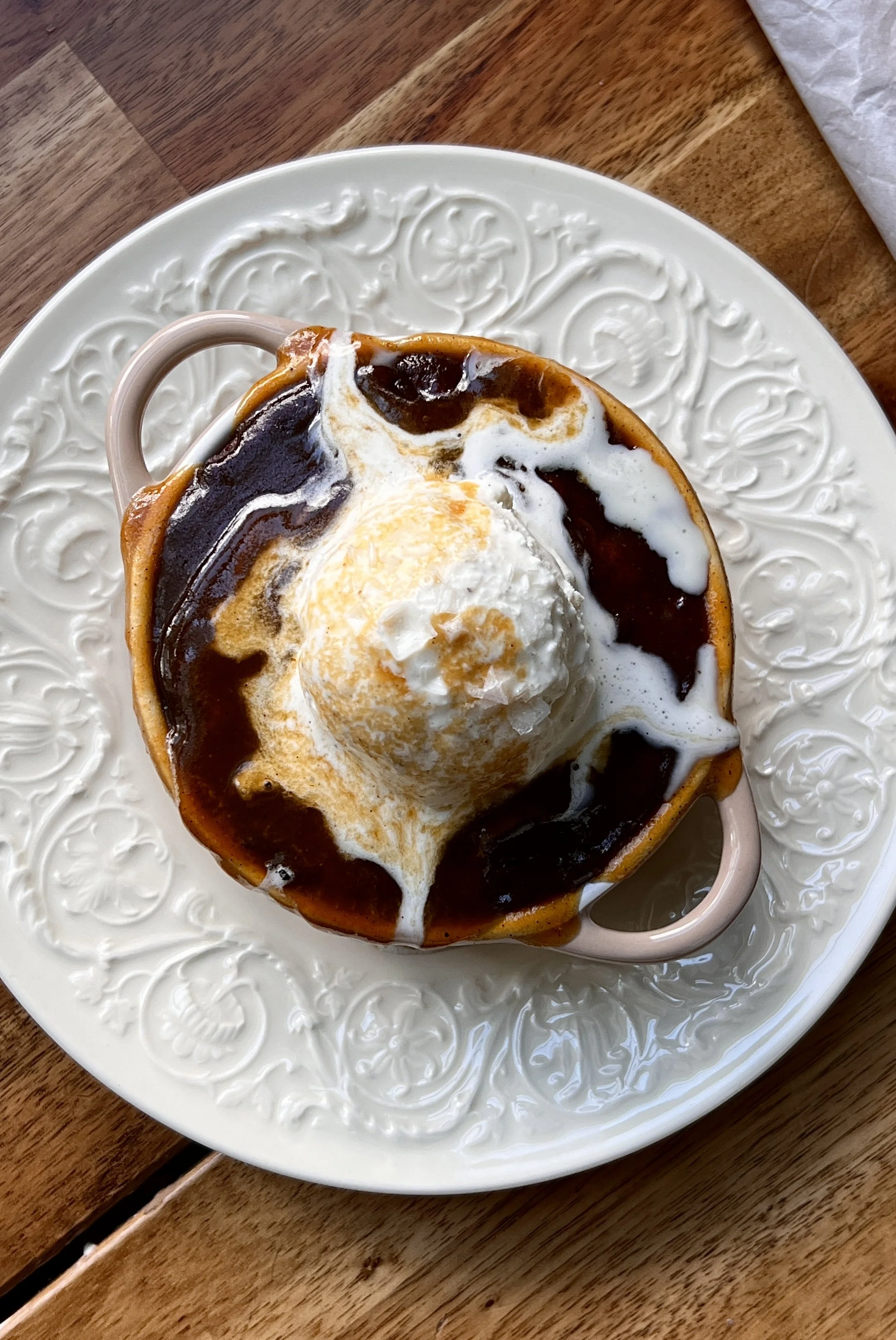 Close-up of Sweet Potato Sticky Toffee Puddings topped with melting vanilla ice cream and drizzled with warm toffee sauce