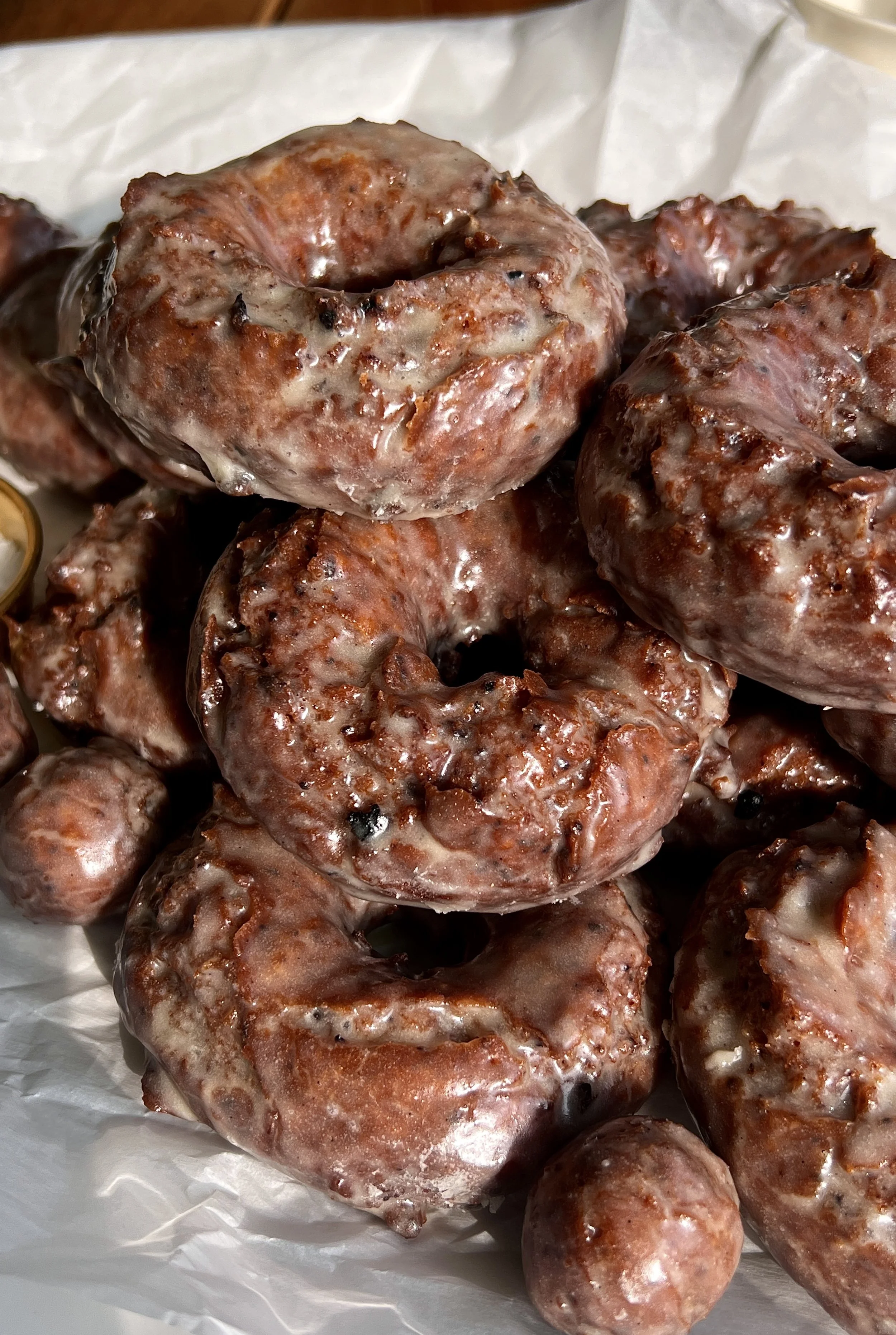 Stack of old-fashioned blueberry cake donuts coated in vanilla bean glaze.