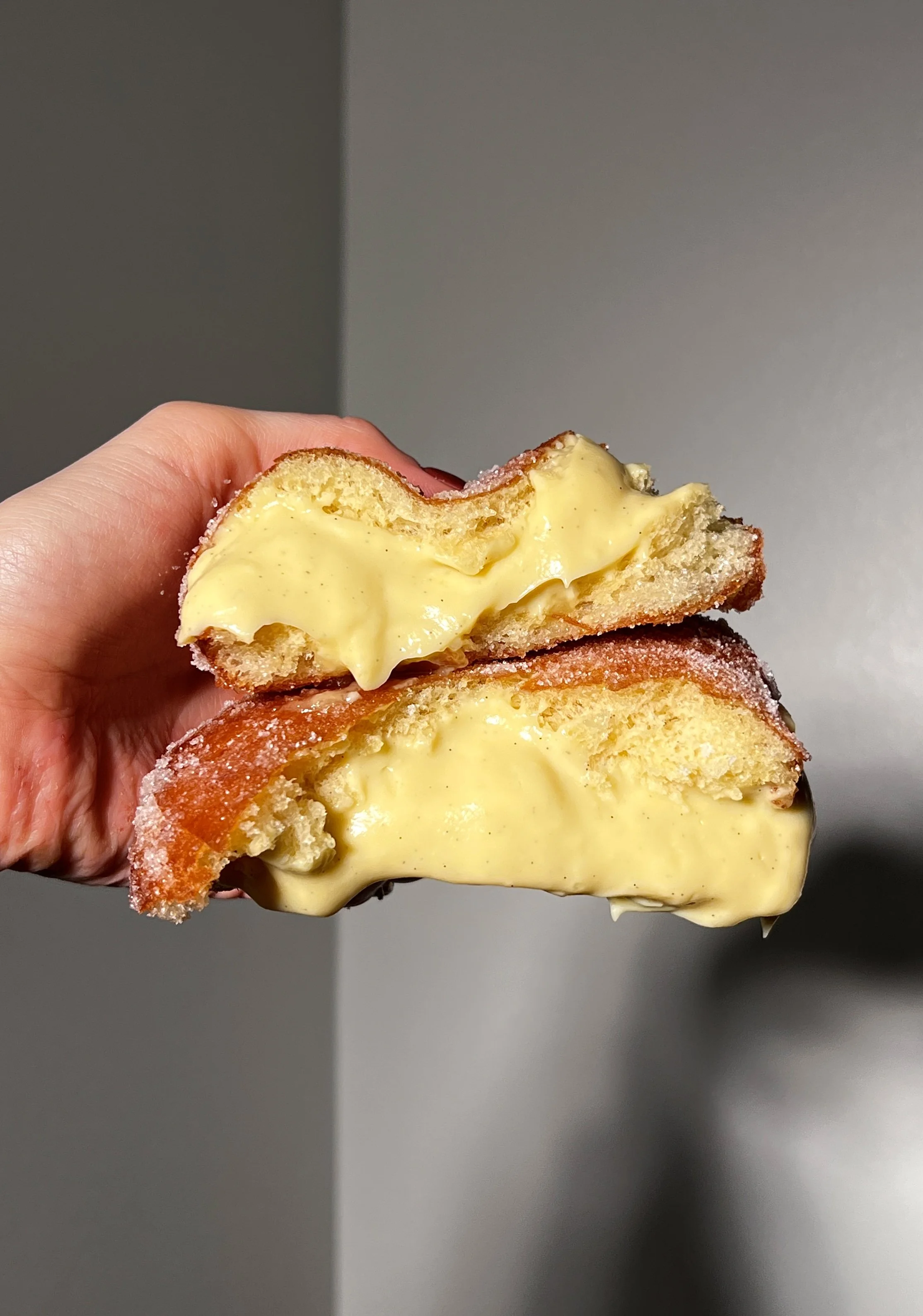 Close-up of vanilla bean coconut cream bomboloni showing the fluffy interior and rich coconut cream filling.