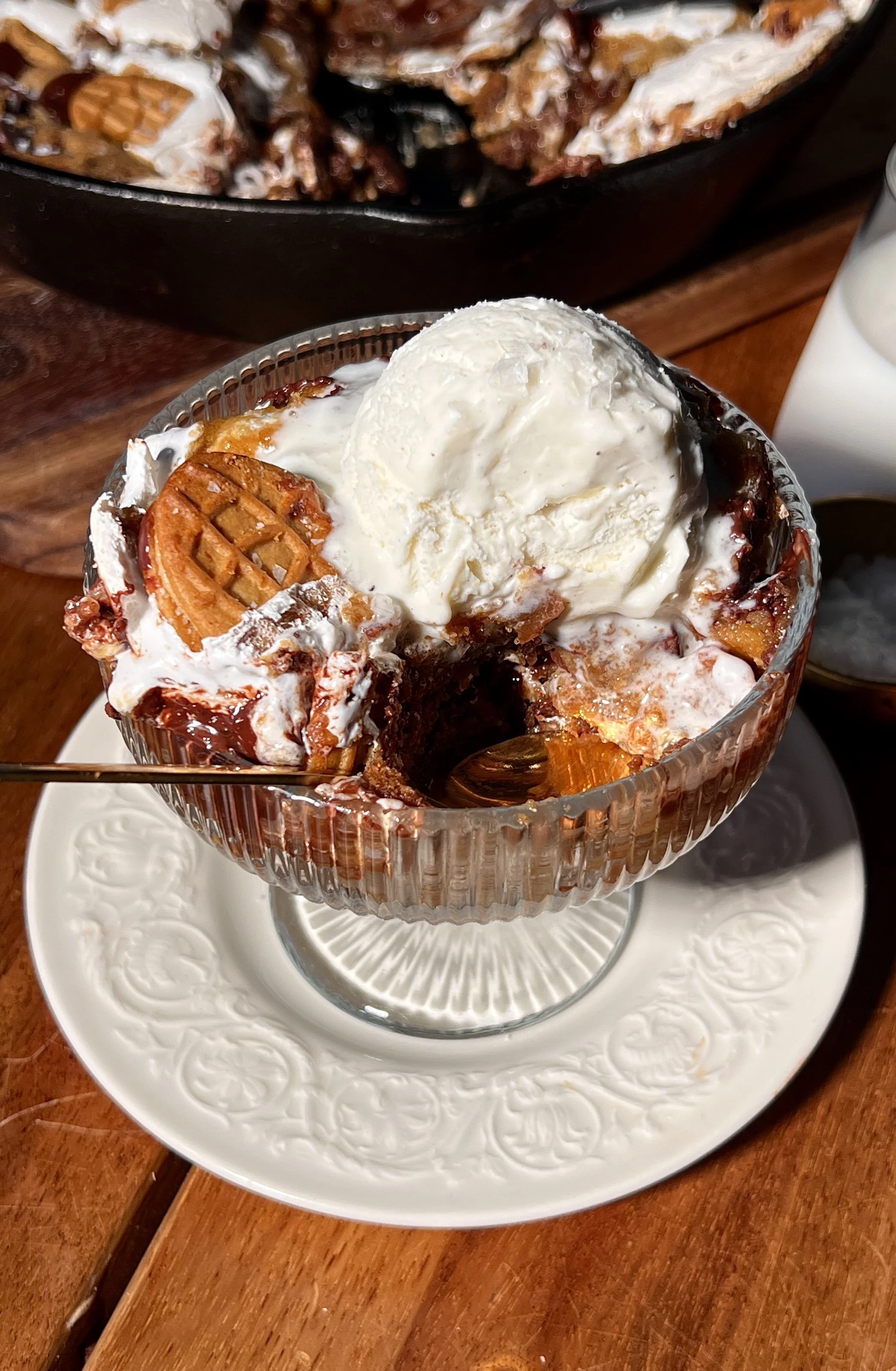 Fluffernutter chocolate chip cookie skillet with brown butter, featuring a gooey center, golden crisp edges, melty chocolate chips, peanut butter, marshmallow fluff, crushed Nutter Butter cookies, and vanilla ice cream on top.