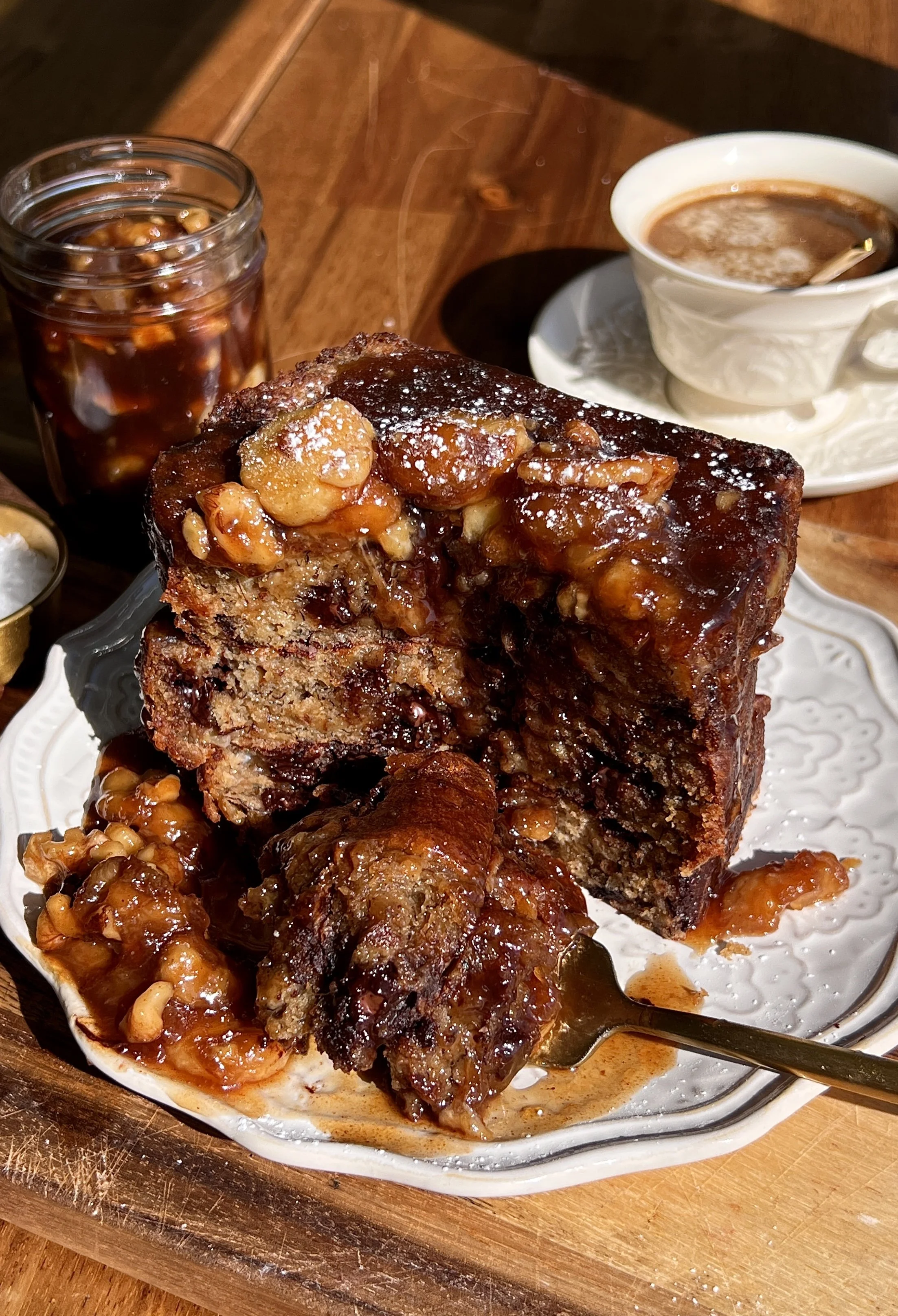Golden banana bread French toast served with warm bananas foster topping and a cup of coffee.
