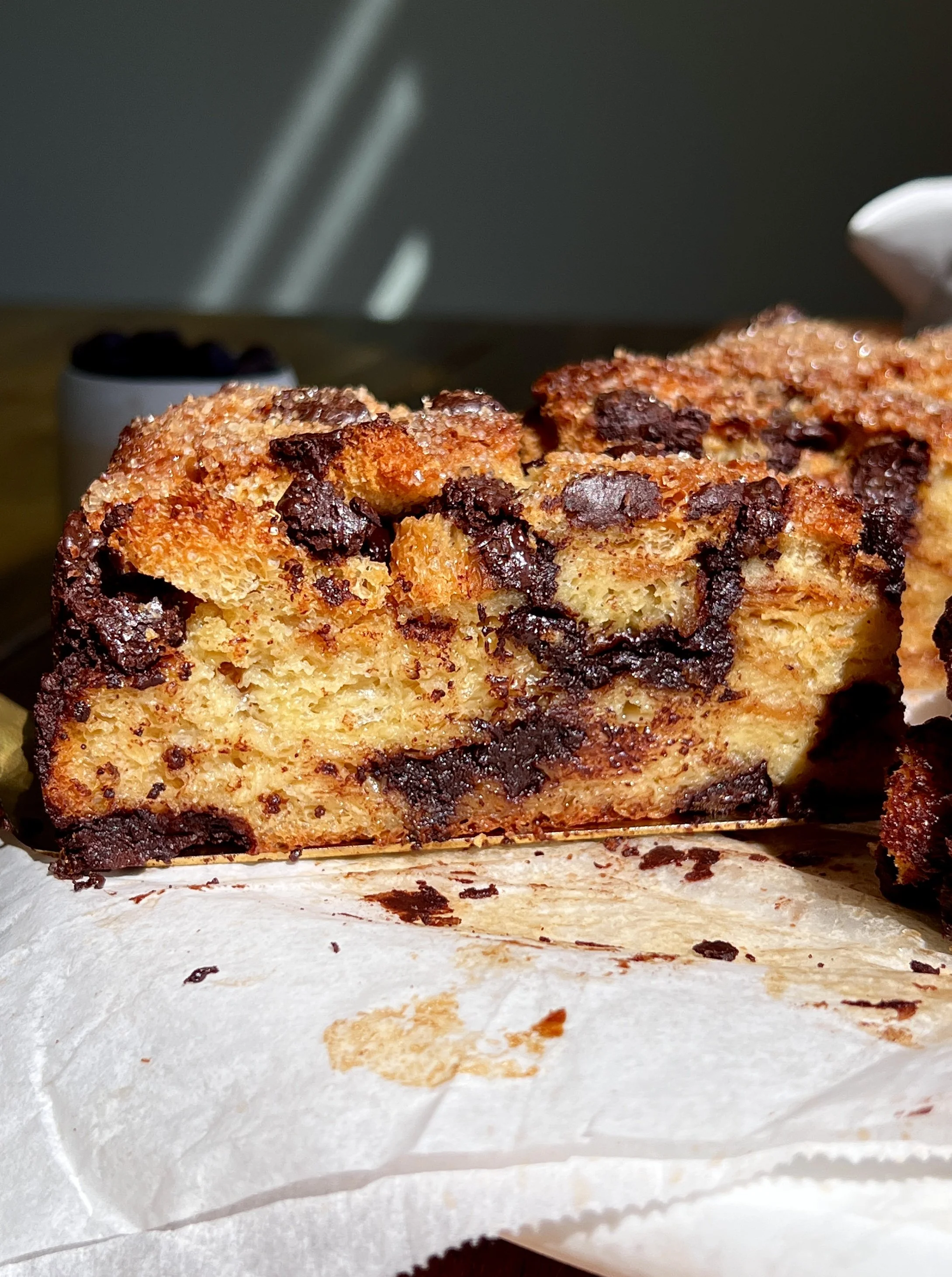 Close-up of chocolate chip bread pudding with soft custard-soaked brioche and melted chocolate chips.