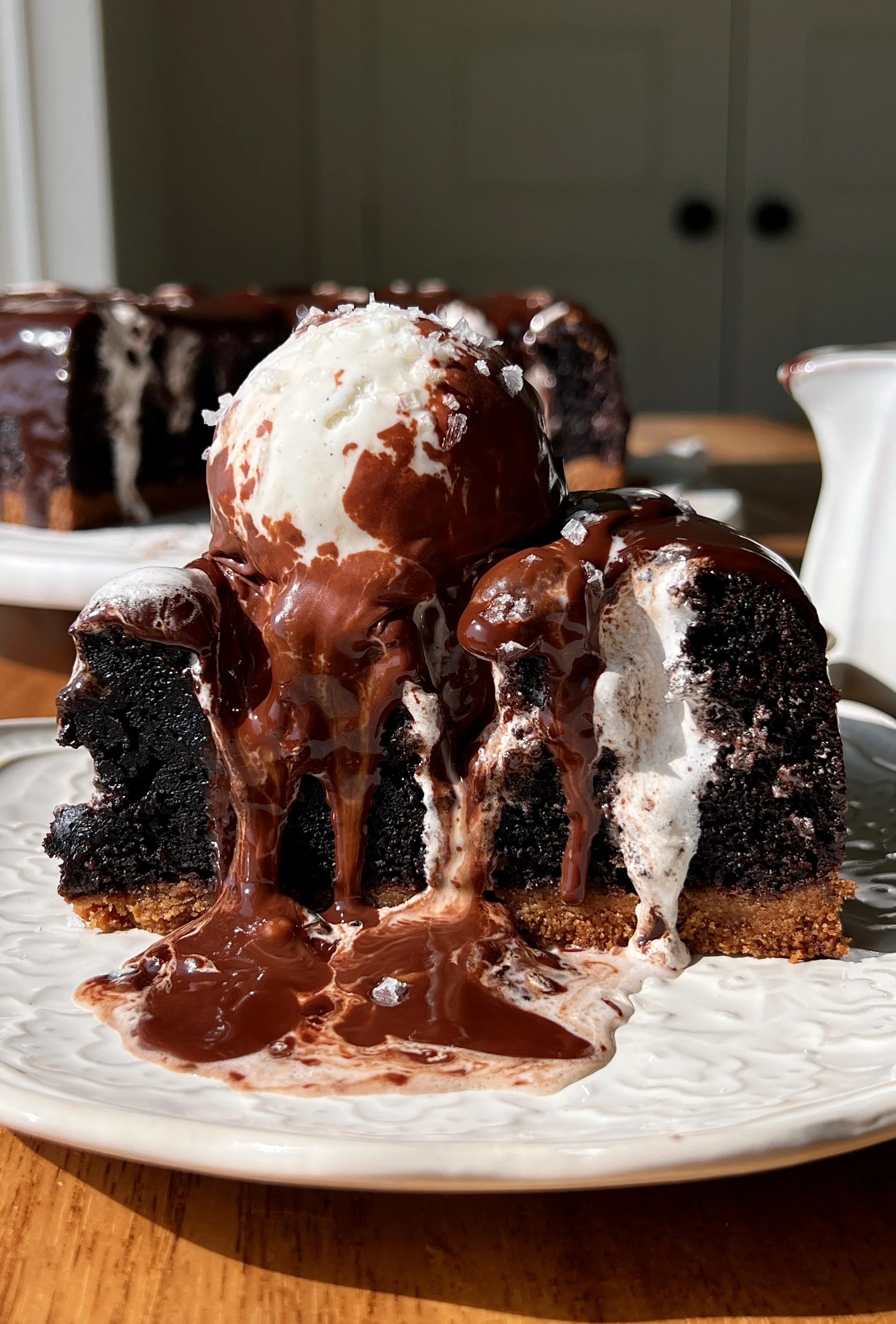 S'mores chocolate mud cake with a golden buttery graham cracker crust, marshmallow fluff piped throughout, and a velvety chocolate ganache on top served warm with a scoop of vanilla ice cream.