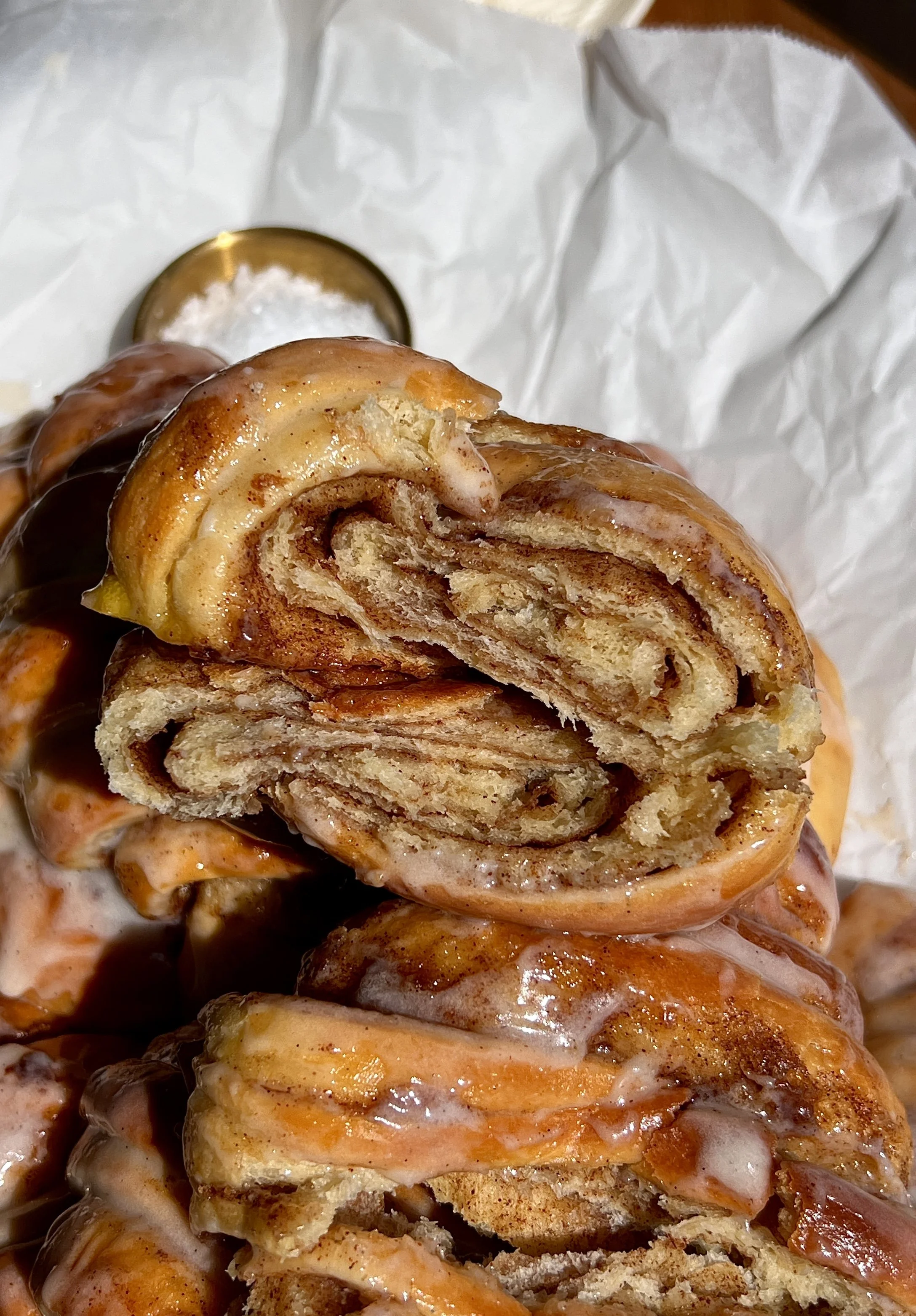 Broken open cinnamon roll croissant showing soft, fluffy layers and melty cinnamon filling.