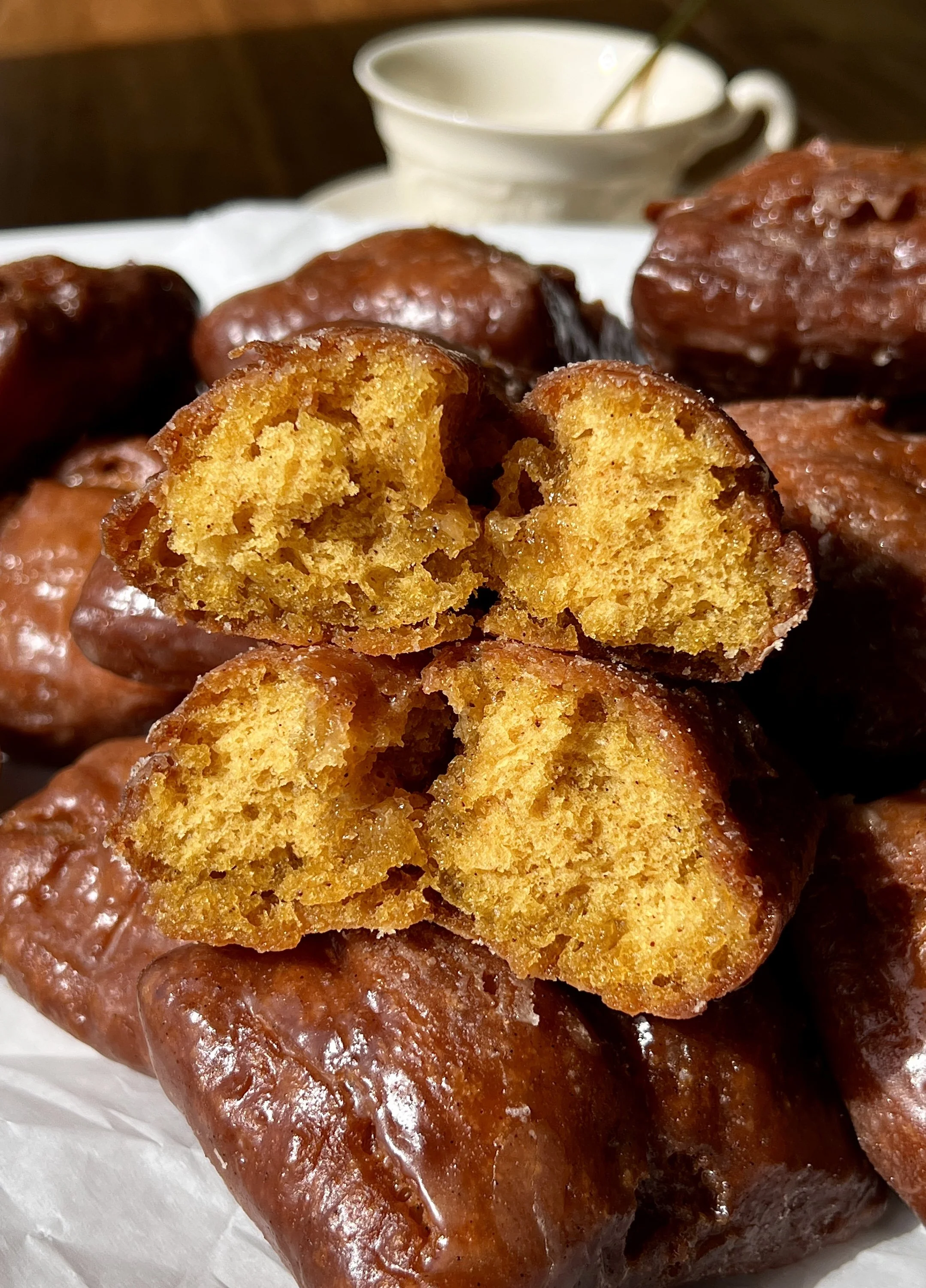 Close-up of an old-fashioned pumpkin donut bar showing the soft and fluffy delicate crumb with a beautifully golden and crisp exterior coated in a salted maple cinnamon glaze throughout.