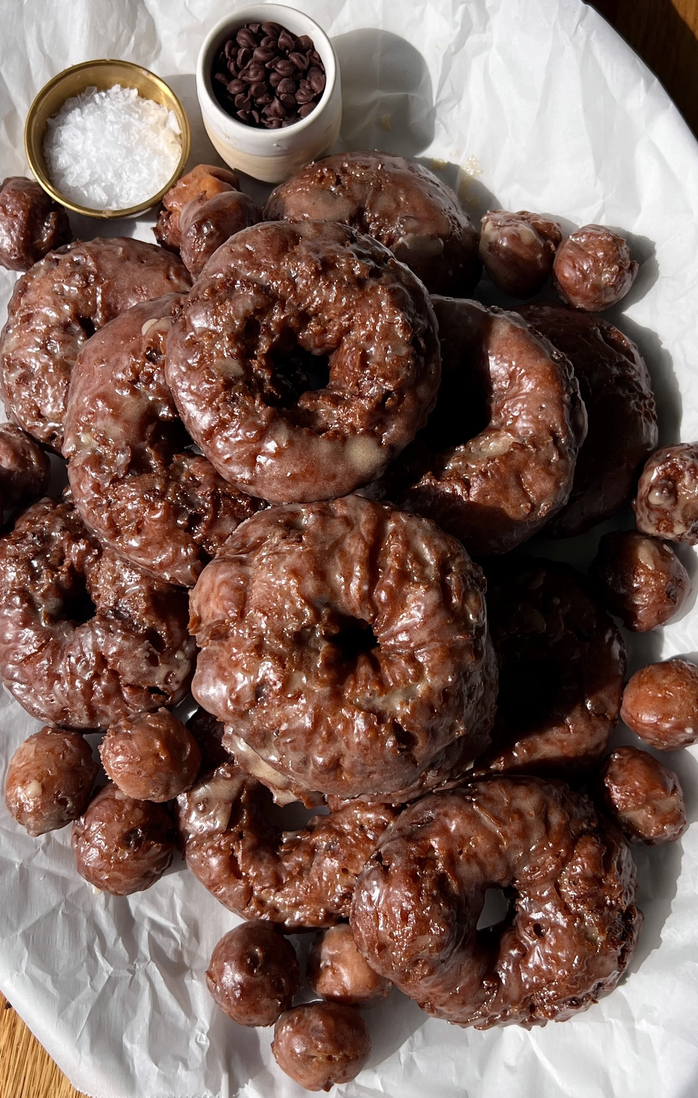 Old-fashioned chocolate chip banana bread donuts coated in a salted brown butter honey glaze served warm with a hot cup of coffee.
