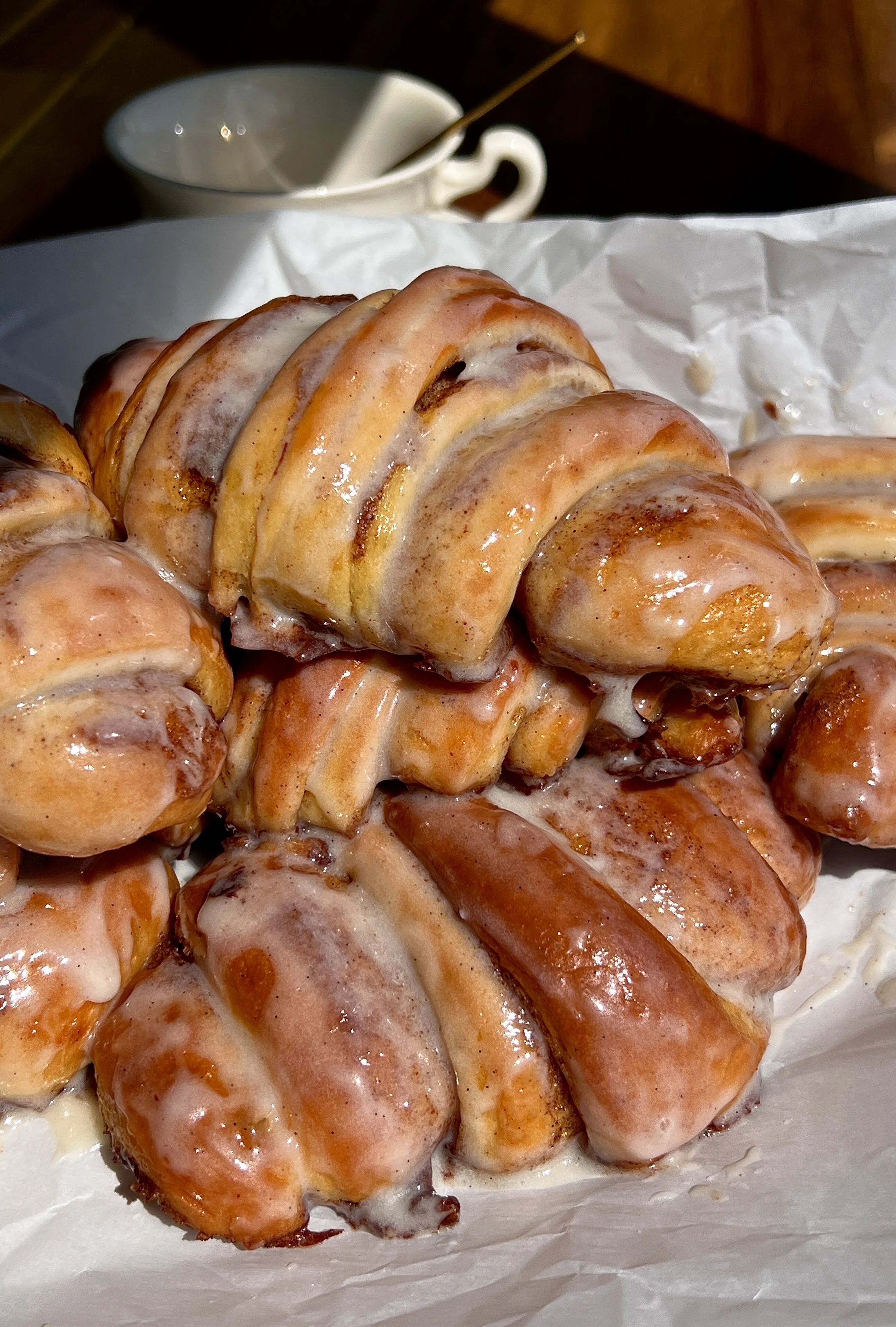 Cinnamon roll croissants topped with cream cheese glaze and served warm.