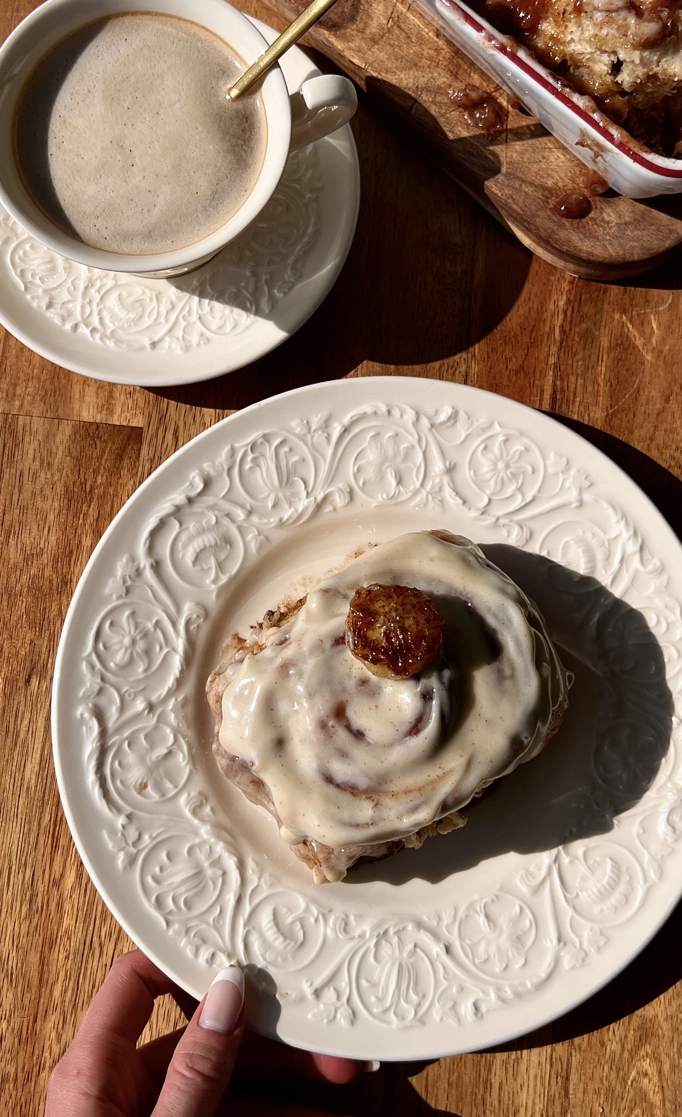 Incredibly soft and fluffy banana bread buttermilk cinnamon rolls with a warming banana bread cinnamon filling and beautifully golden caramelized edges finished with honey brown sugar cream cheese frosting served warm with a hot cup of coffee.