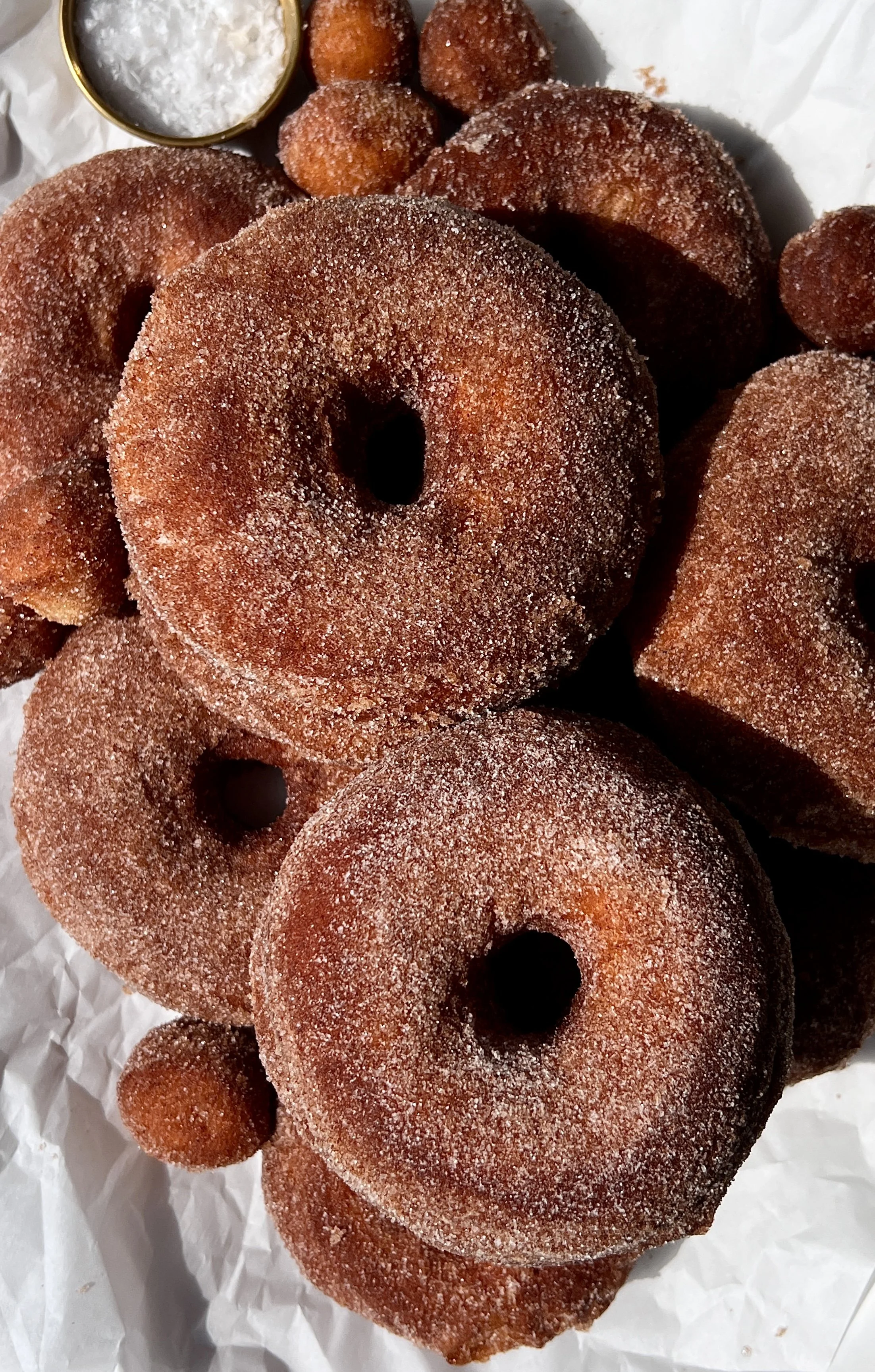 Close-up of a pillowy soft cinnamon sugar milk bread donut showing the beautifully golden exterior with just the right amount of chew and the incredibly soft and fluffy interior throughout.