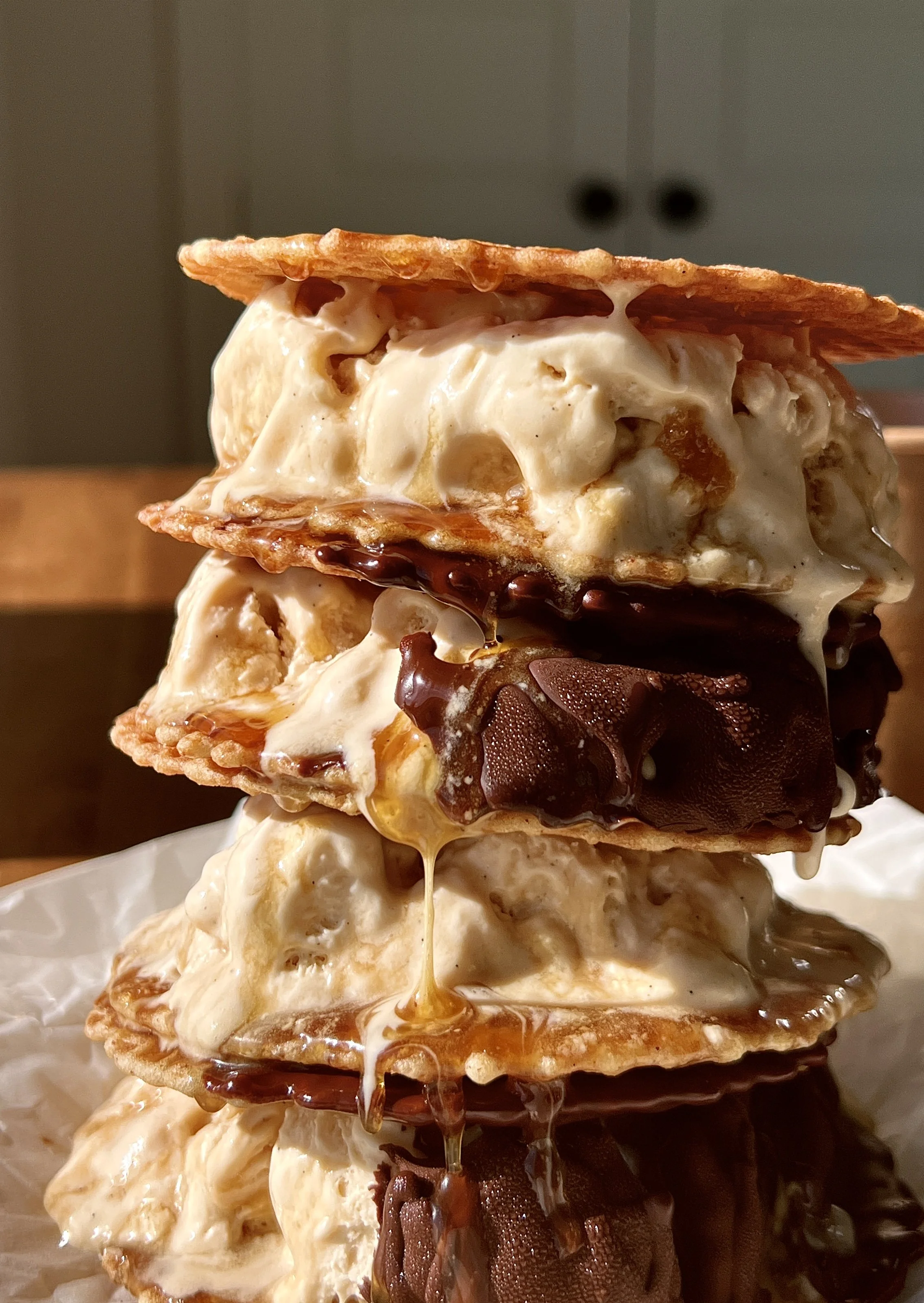 Dreamy salted maple swirl ice cream sandwiches made with rich maple custard ice cream and a thick salted maple syrup swirl sandwiched between buttery waffle cookies and dipped in chocolate.
