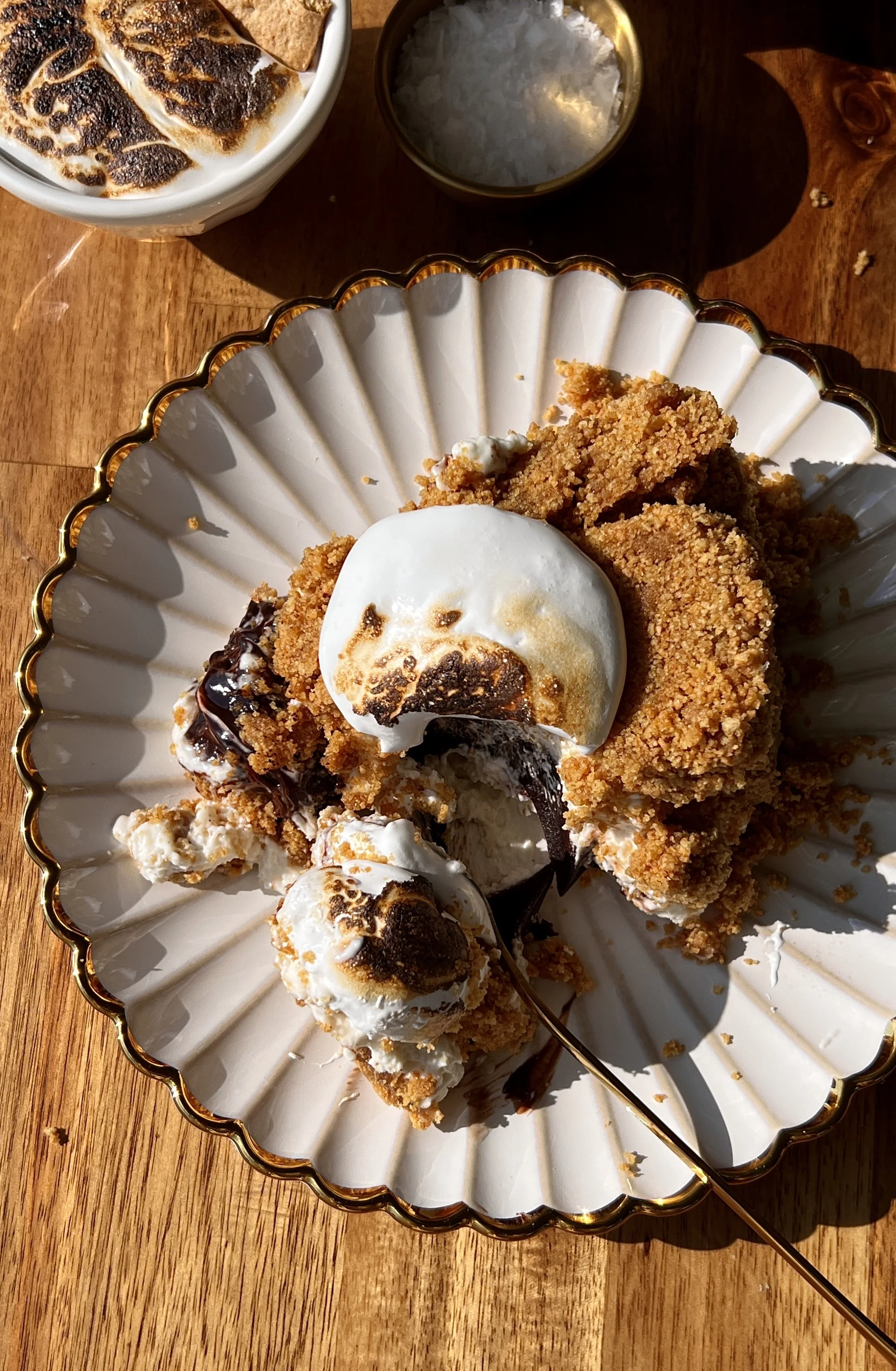 Upside down s'mores no-bake cheesecake with a perfectly crunchy graham cracker crust inverted to serve and finished with a dollop of toasted marshmallow fluff on top.
