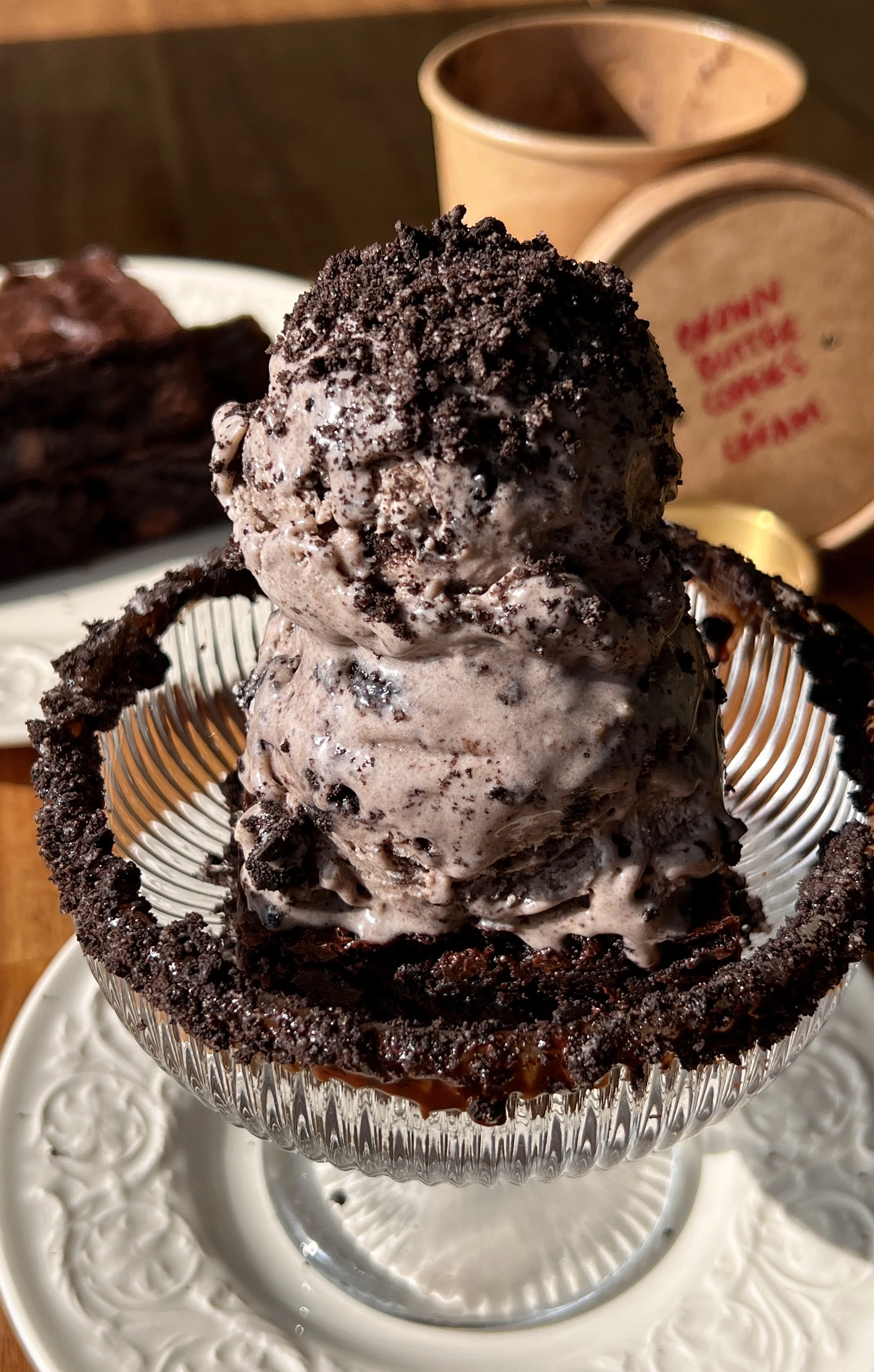 Generous scoop of brown butter cookies and cream ice cream served over a warm brownie with a hot shot of espresso poured over the top for the ultimate affogato style dessert.