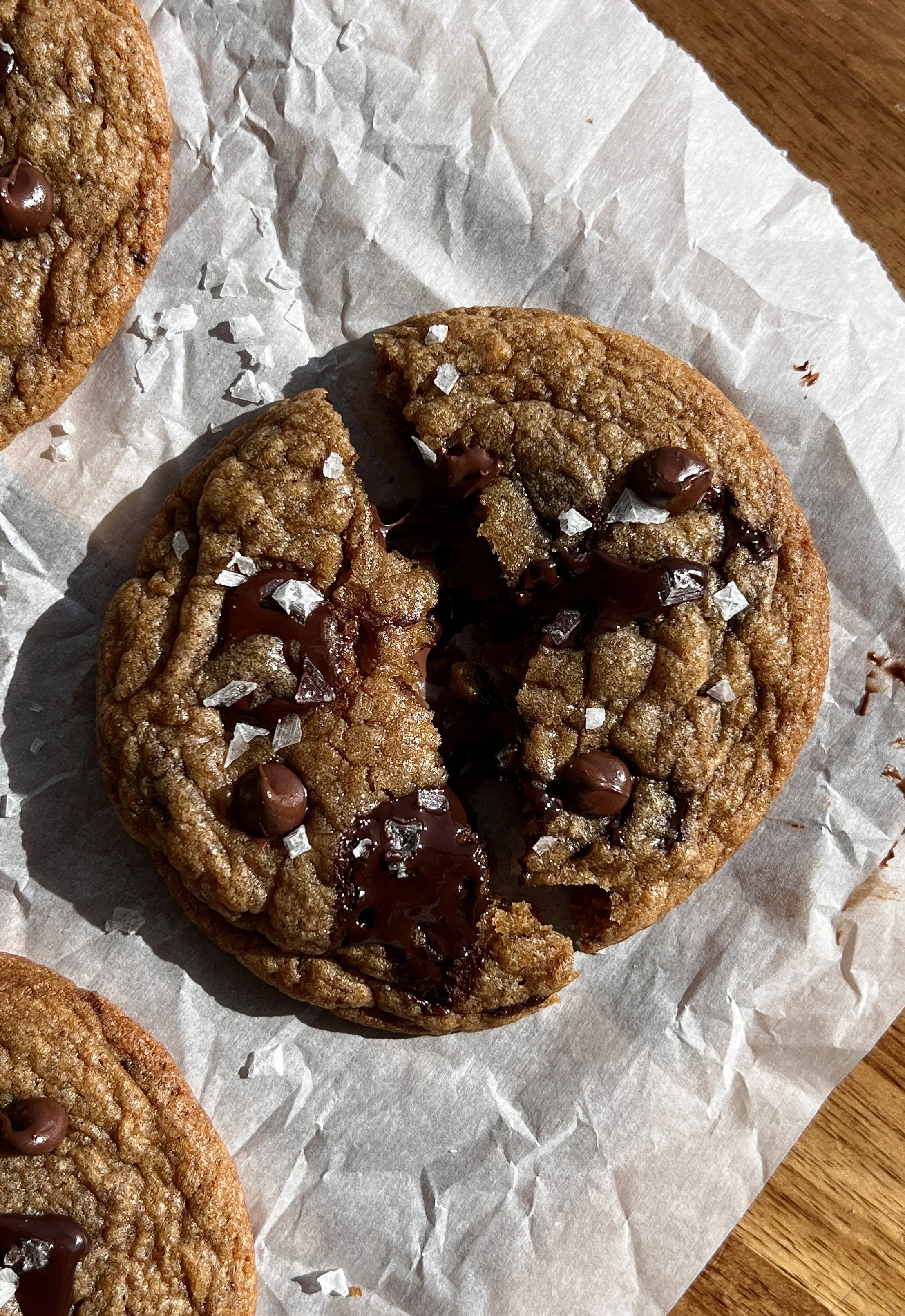 Close-up of a brown butter banana bread cookie showing a gooey Nutella center and melty chocolate chips.
