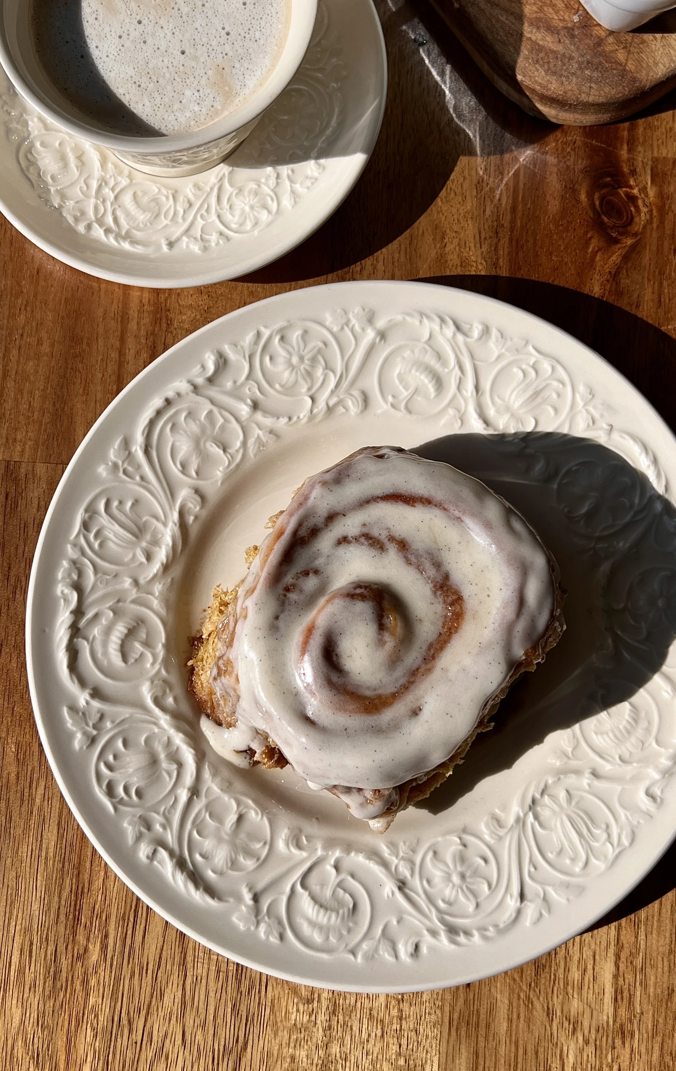 Soft and fluffy homemade pumpkin cinnamon rolls with beautifully golden caramelized edges and a warming gooey pumpkin spice cinnamon filling finished with classic cream cheese frosting served warm with a hot cup of coffee.