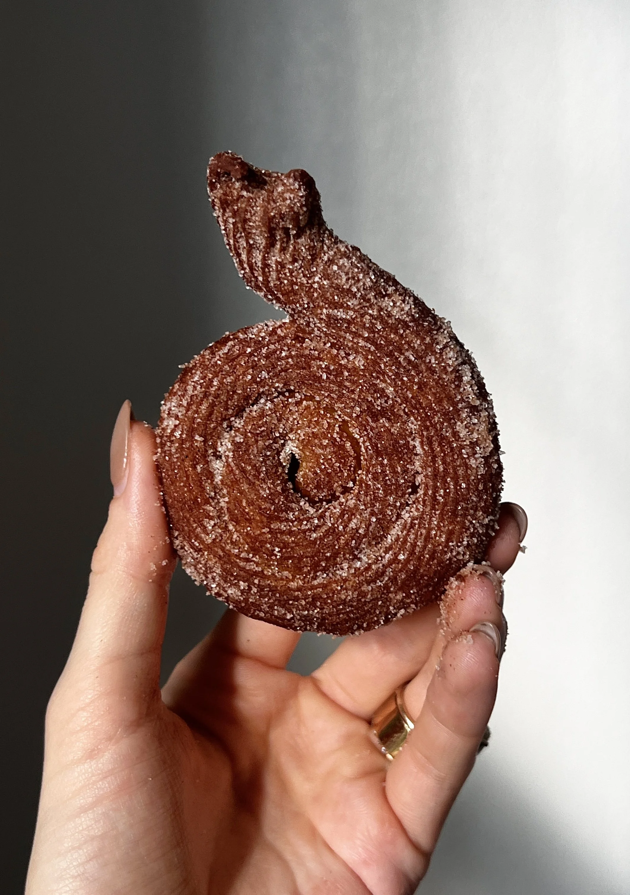 Close-up of pumpkin-shaped Brown Butter Pumpkin Churros coated in cinnamon sugar and served with salted chocolate and caramel sauce