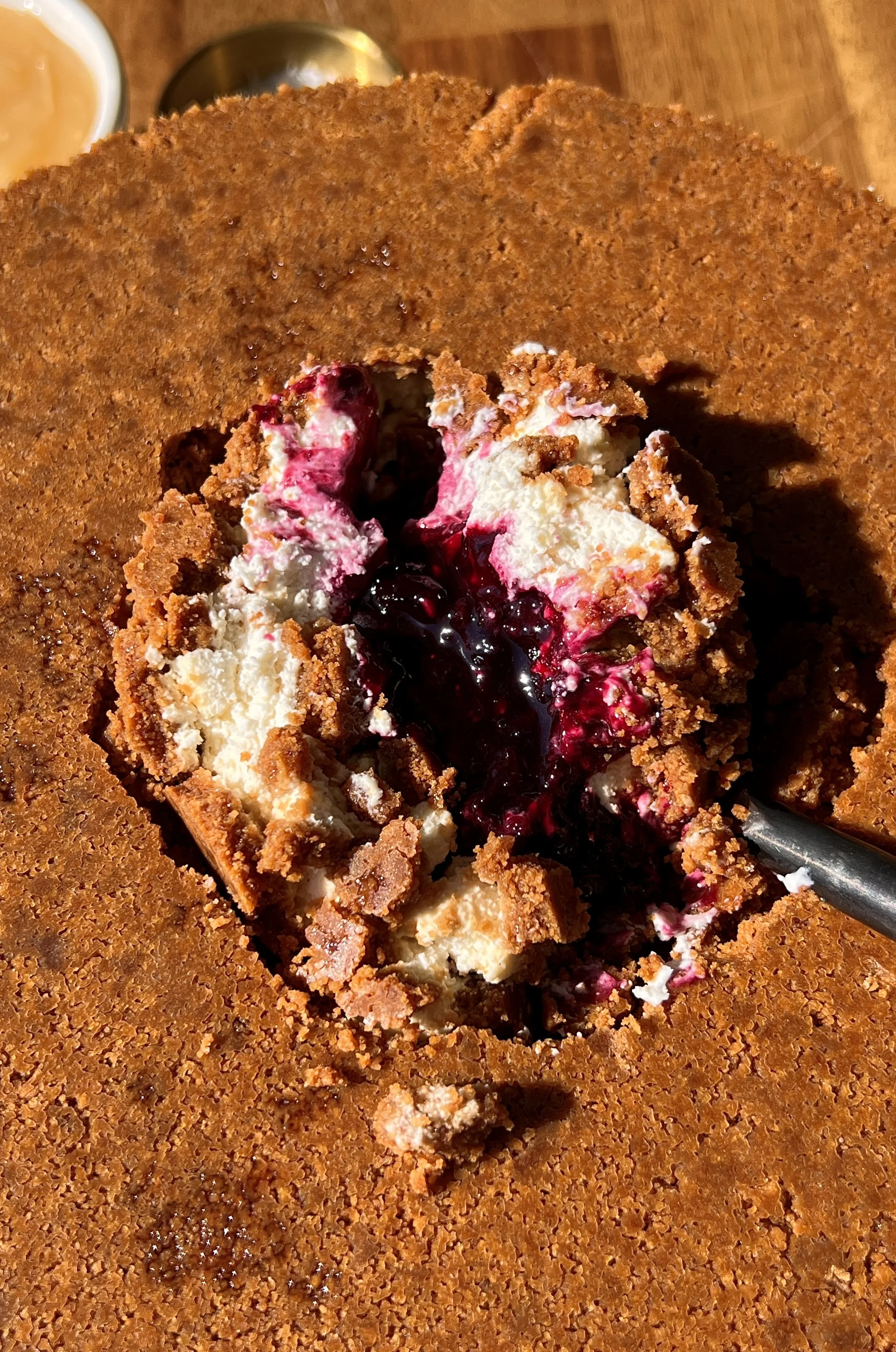 Close-up of an upside down triple berry no-bake cheesecake showing the rich and creamy cheesecake filling and sweet jammy triple berry compote layer throughout.