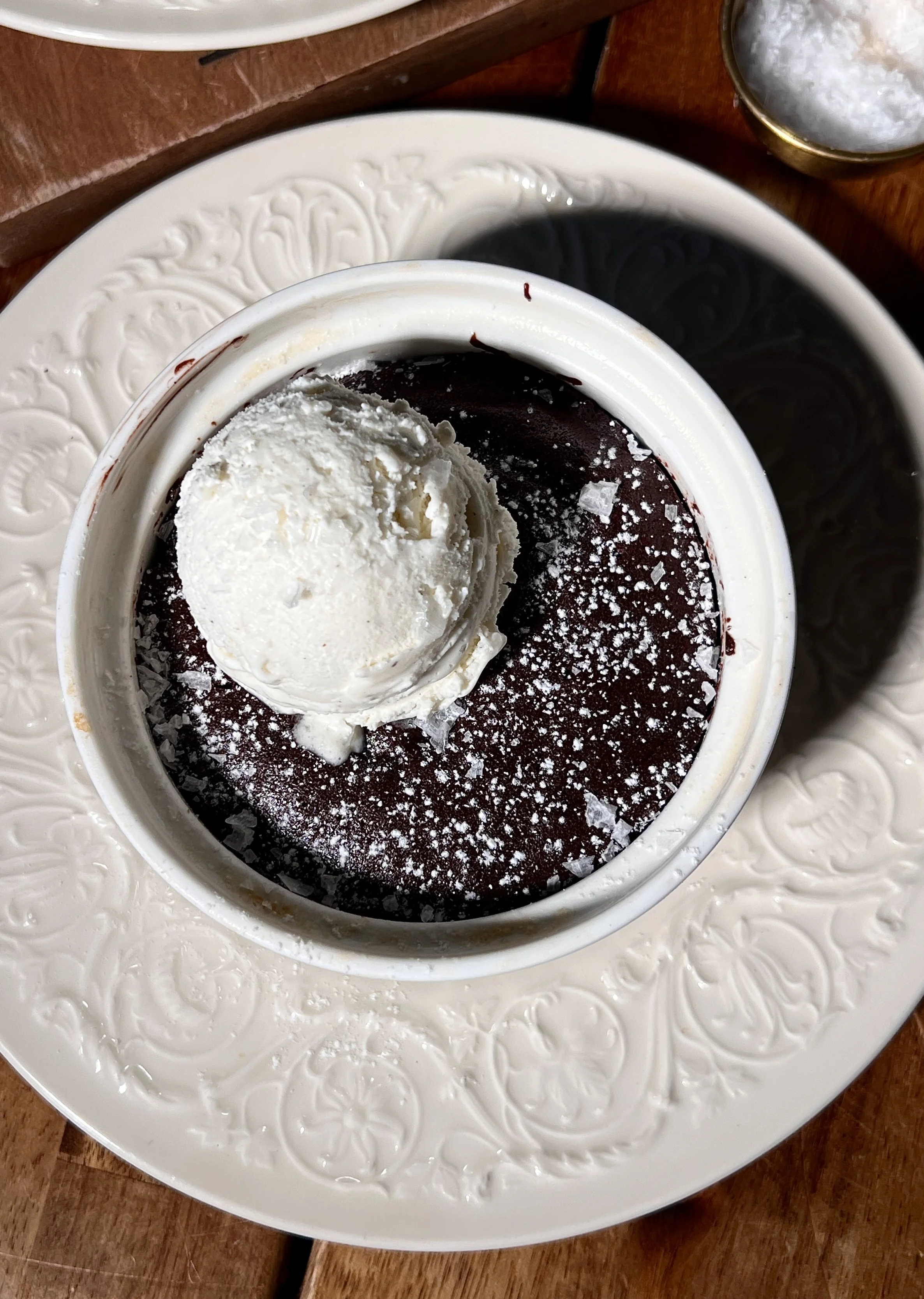 Flourless chocolate cakes for two with a crackly top, powdered sugar, vanilla ice cream, and flaky sea salt.