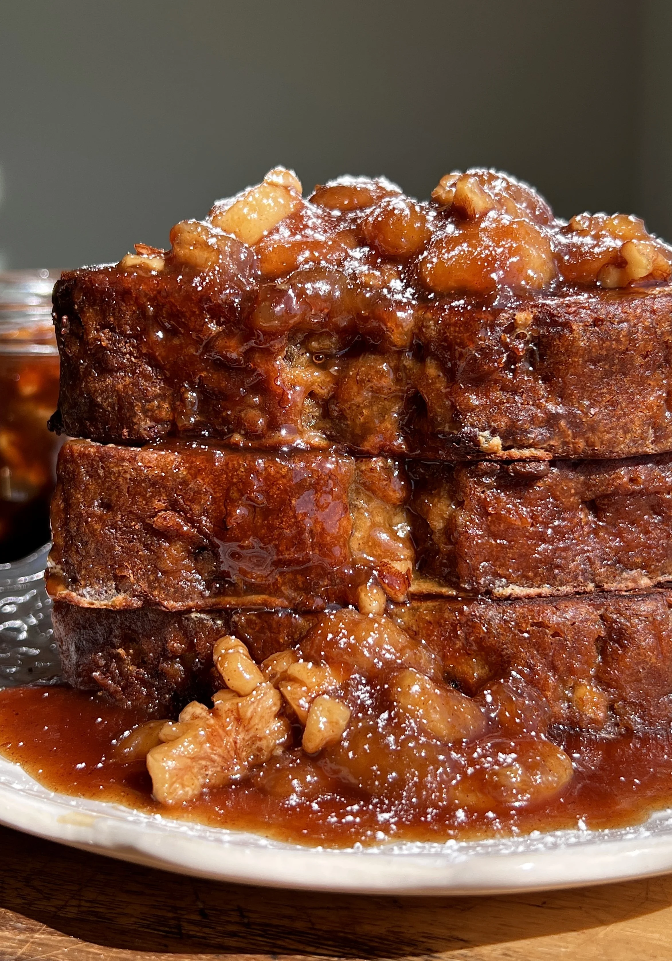 Close-up of banana bread French toast with gooey bananas foster topping and caramel sauce.