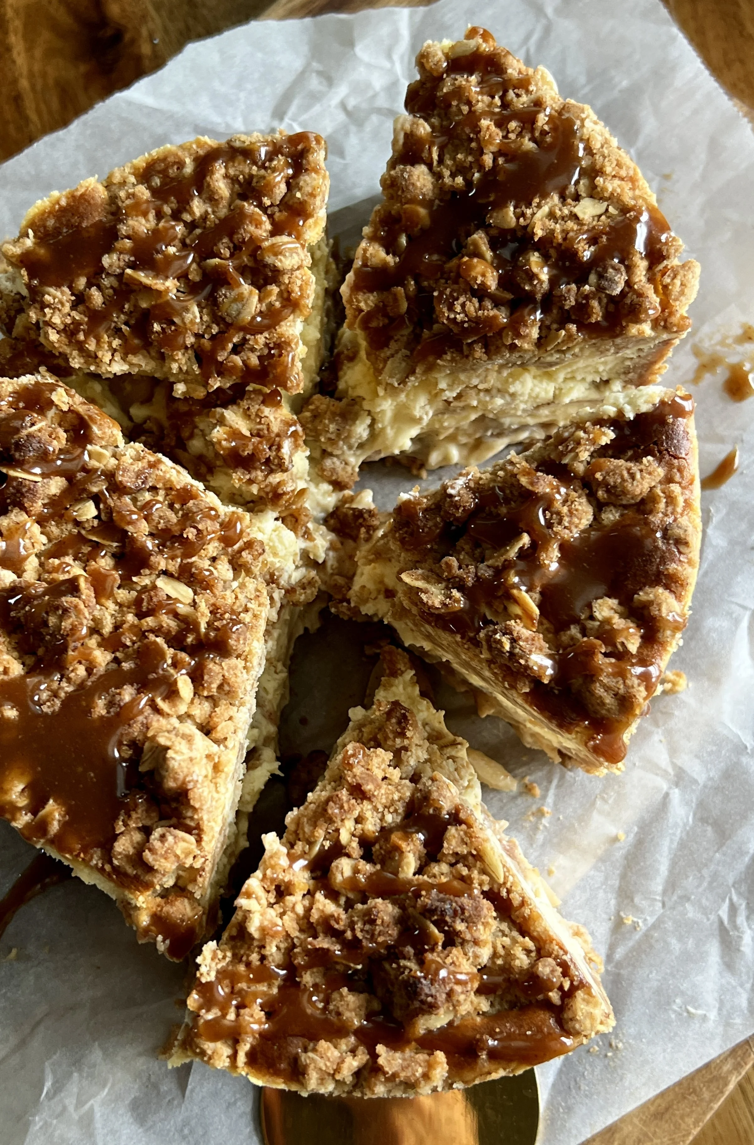 6-inch mini apple crumble cheesecake with a graham cracker crust, apple pie filling, and finished with a drizzle of salted caramel.