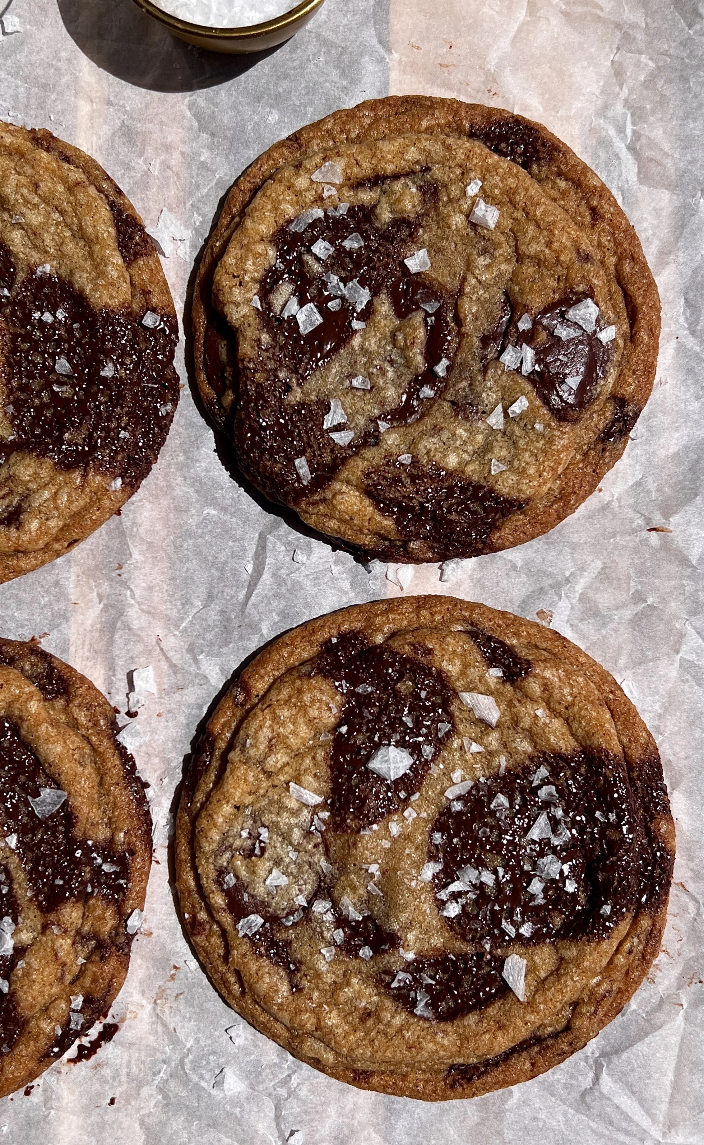 Close-up of brown butter chocolate chip cookies with gooey centers, rippled edges, and melted chocolate pools.
