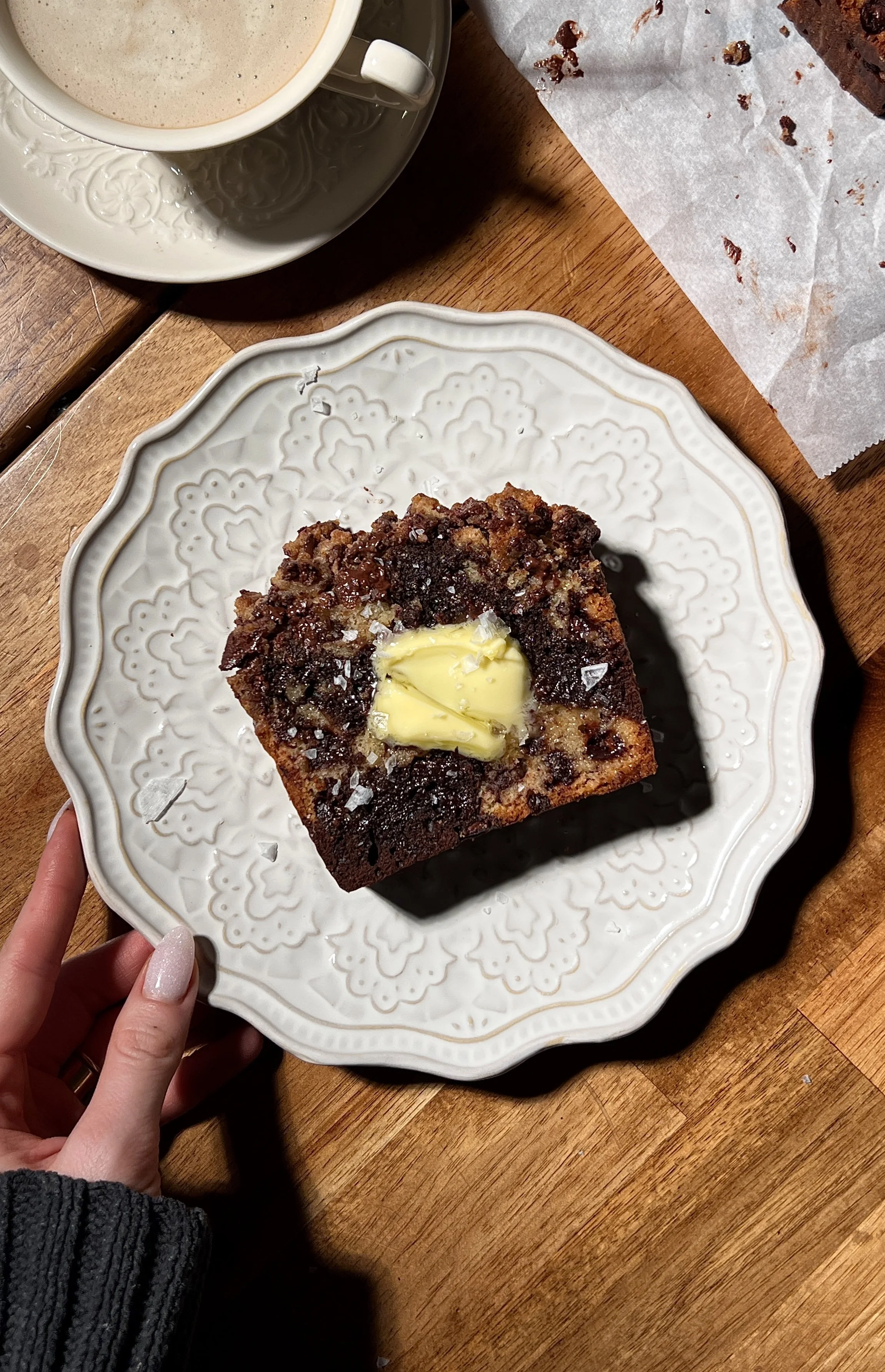 Brown butter marbled chocolate chip crumb loaf cake sliced and served warm, showing vanilla and chocolate swirled crumb, melty chocolate chips, and a buttery crumb topping, finished with flaky sea salt and coffee on the side.