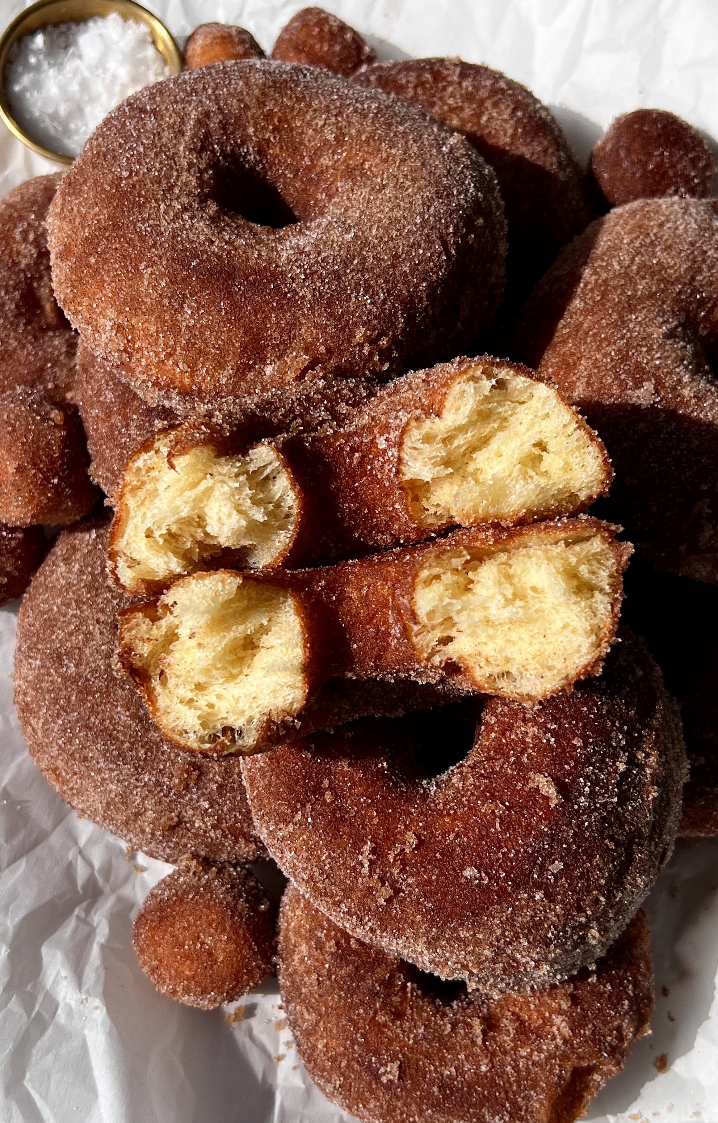 Close-up of a pillowy soft cinnamon sugar milk bread donut showing the beautifully golden exterior with just the right amount of chew and the incredibly soft and fluffy interior throughout.