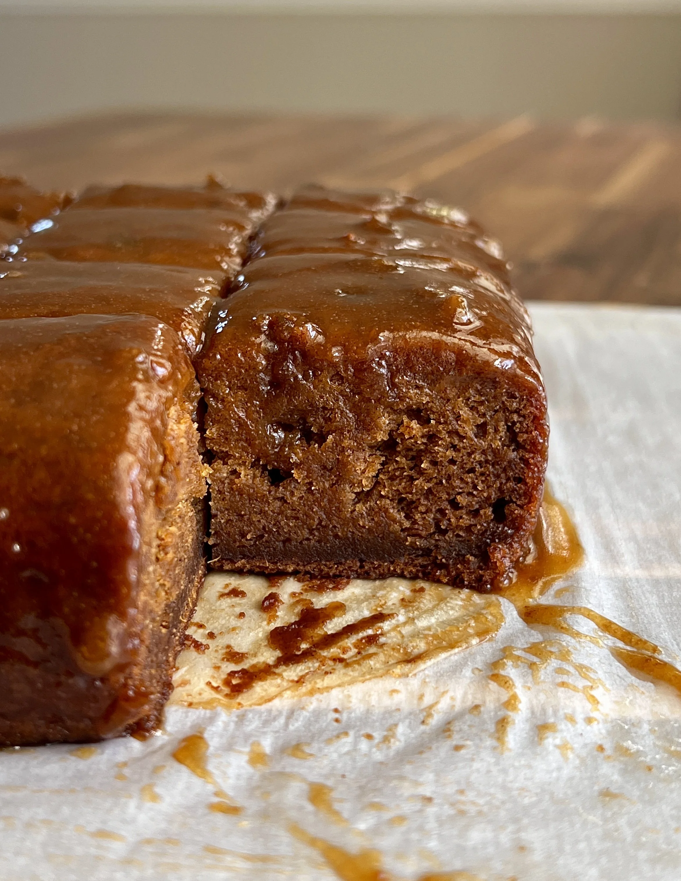 Sweet potato sticky toffee pudding served warm with a scoop of vanilla ice cream and drizzled with sweet potato sticky toffee sauce."