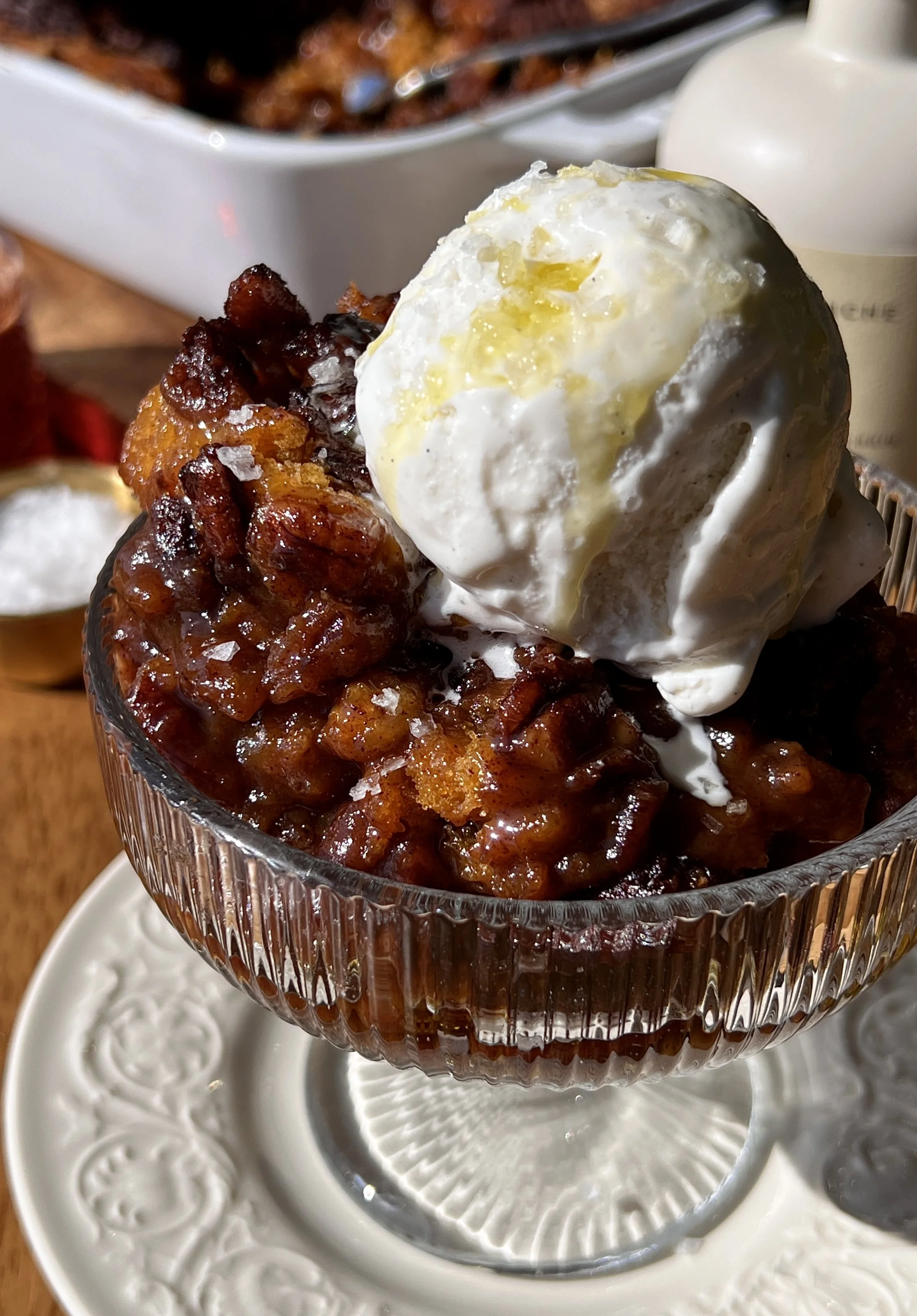 Close-up of a brown butter sweet potato pecan pudding cake showing the beautifully golden and slightly crisp cake top with a warm gooey and syrupy bottom throughout.