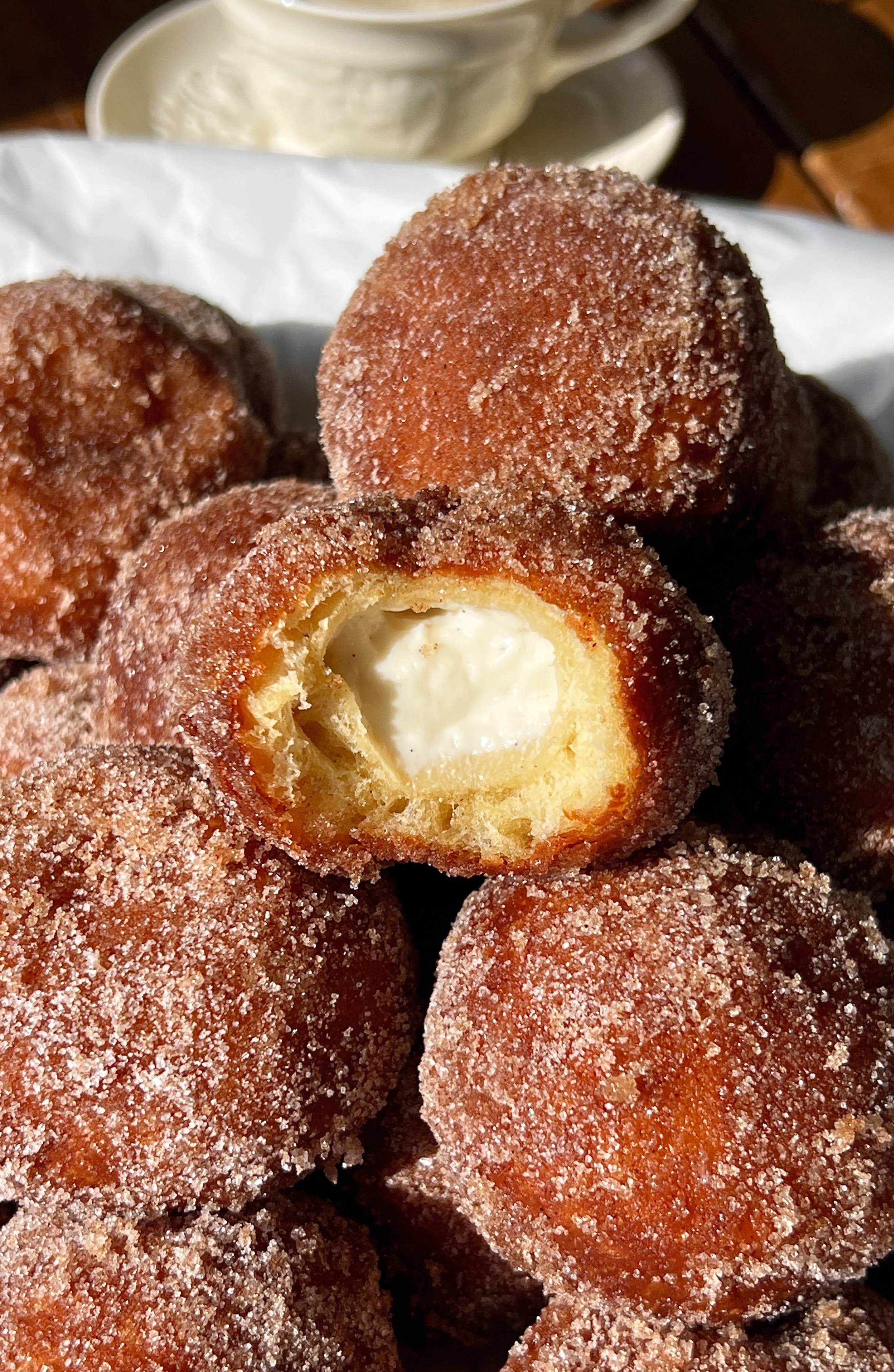 Apple cider cinnabon delight with a bite taken out showing the soft pillowy golden apple cider dough and sweet tangy cream cheese filling melting inside rolled in cinnamon sugar.