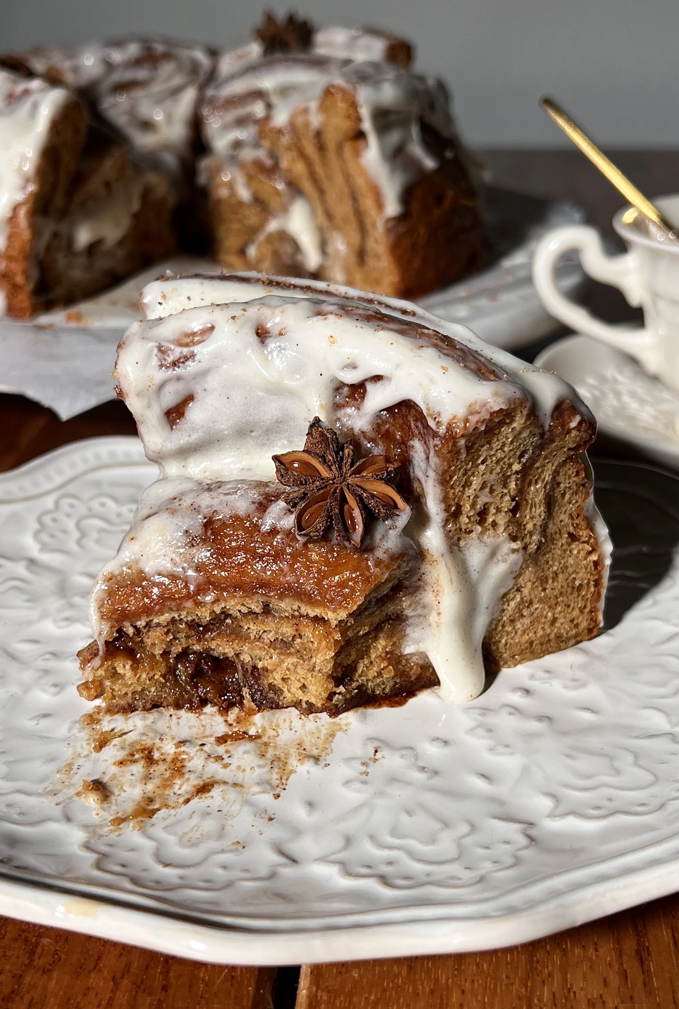 Close-up of a giant gingerbread cinnamon roll showing its soft, gooey center and cream cheese frosting.