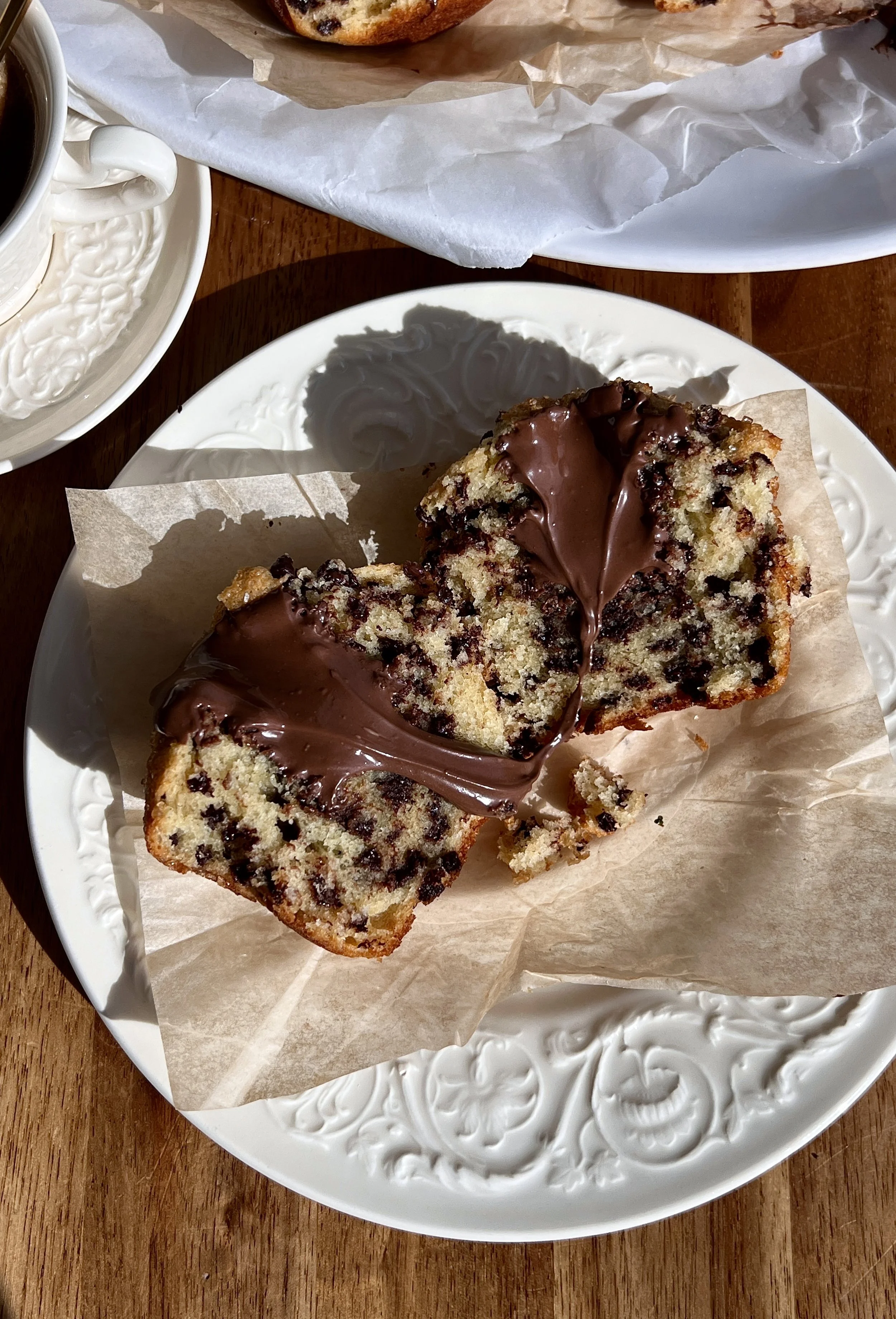 Close-up of a Nutella stuffed chocolate chip muffin showing melty chocolate chips and gooey center.