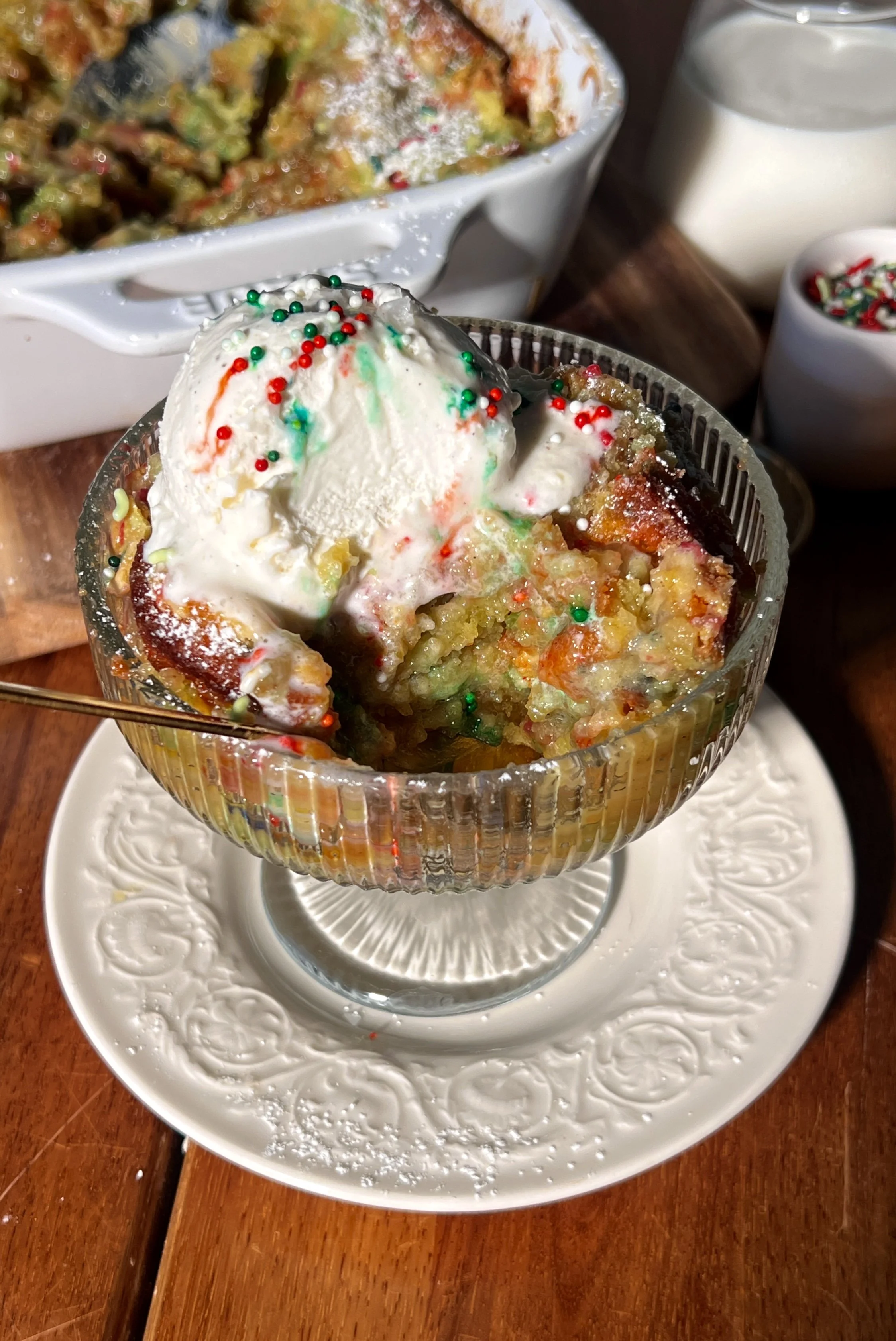 Warm slice of sugar cookie gooey butter cake with a soft sugar cookie base, a gooey cream cheese topping, a crackly golden surface, and a scoop of vanilla ice cream melting beside it.