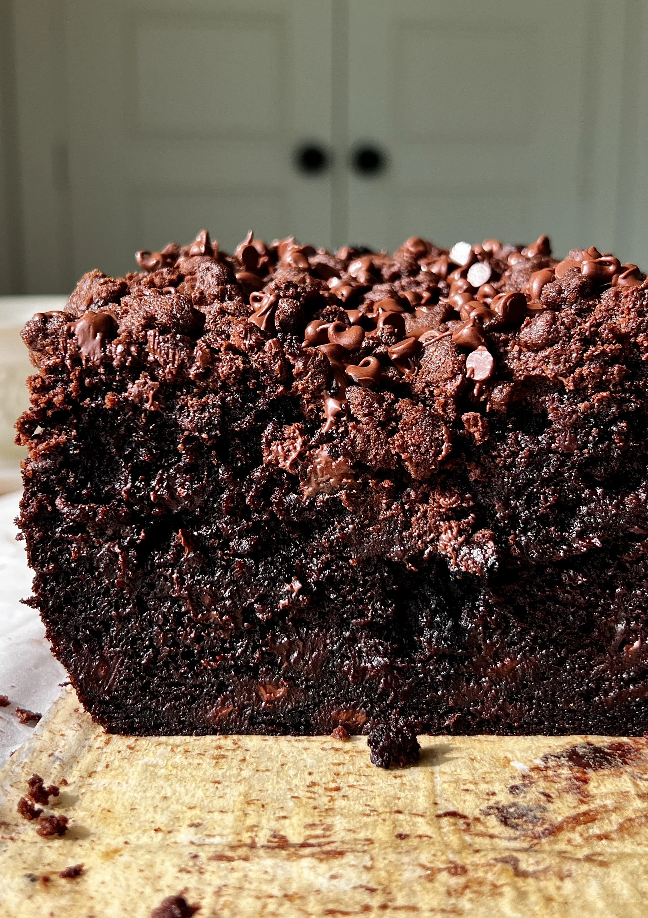Close-up of a soft and fluffy double chocolate crumb banana bread with brown butter showing the rich chocolate crumb and melty chocolate chips throughout.
