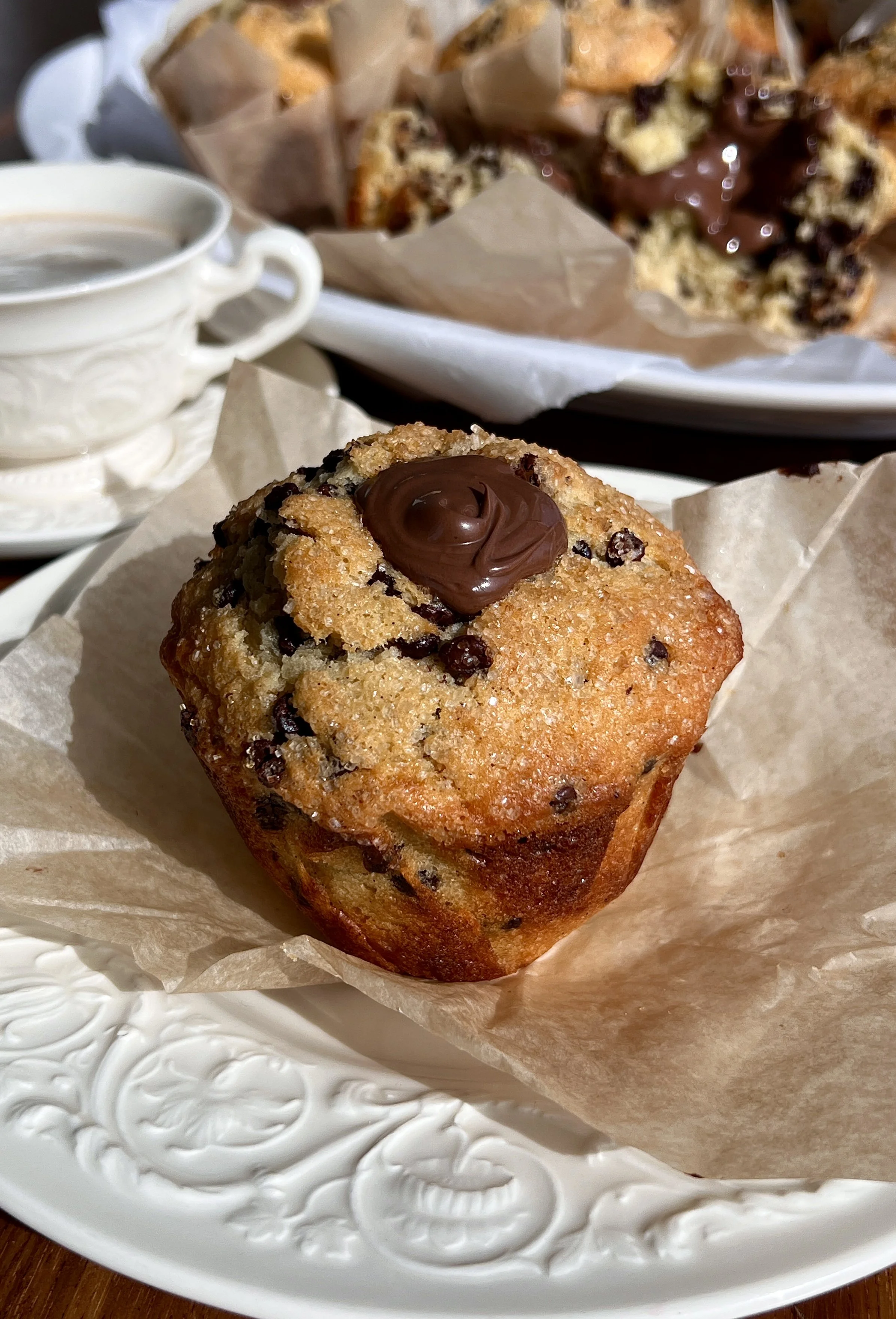 Close-up of a Nutella stuffed chocolate chip muffin showing melty chocolate chips and gooey center.