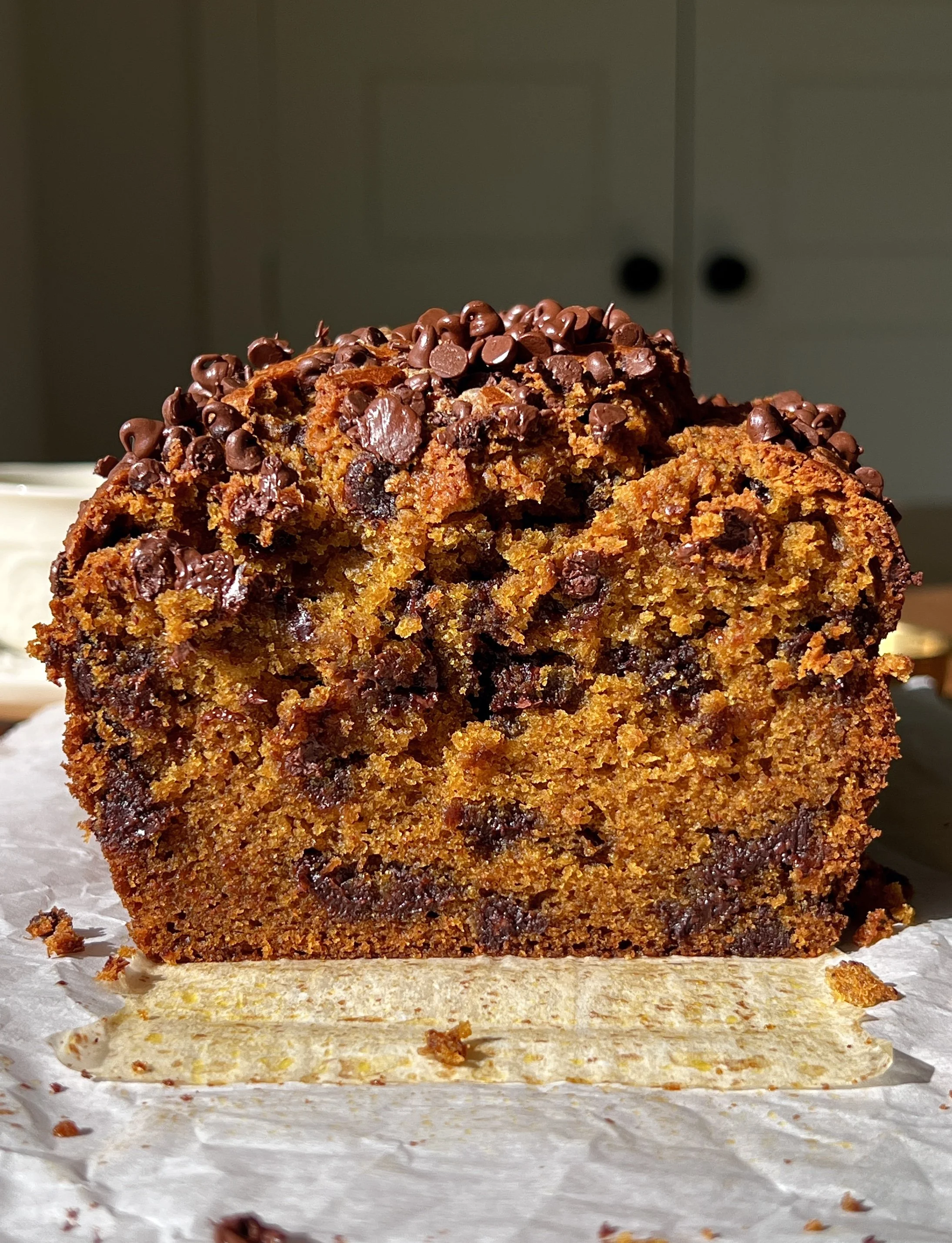 Brown butter chocolate chip pumpkin bread with a perfectly golden and slightly crisp exterior and soft tender crumb served warm with a pat of butter and a sprinkle of flaky sea salt.